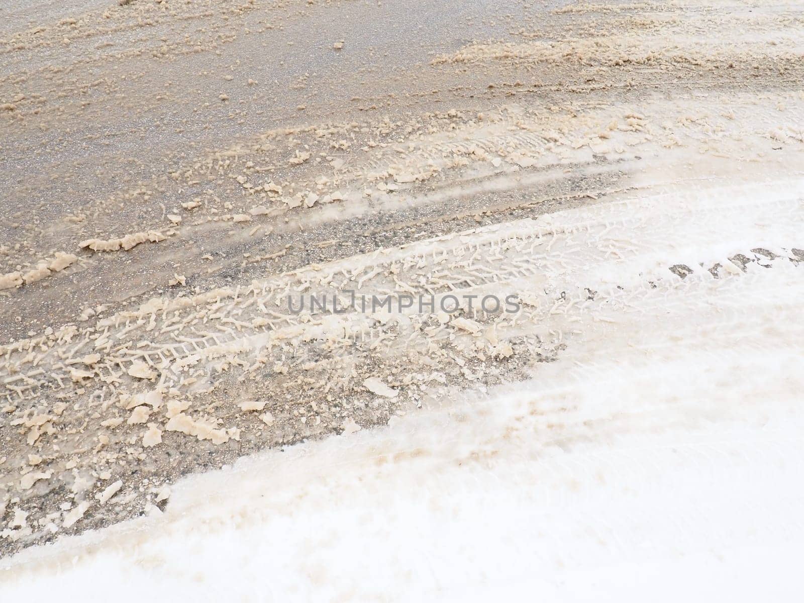 Snowdrifts on the side of the road. Bad weather and traffic. Snow on asphalt. Difficult driving conditions. Winter slosh on the road. Braking distance of a car
