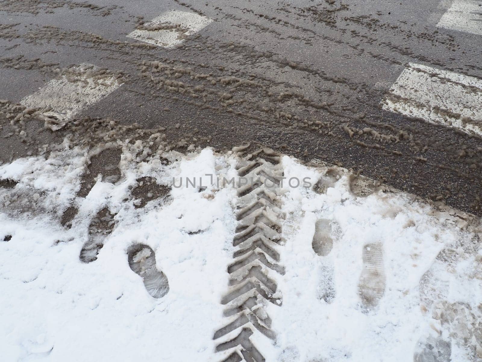 A fork or siding from a roundabout. Snowdrifts on the side of the road. Bad traffic weather. Footprints in the snow. Difficult driving conditions. Winter slosh on the road. Braking distance of a car