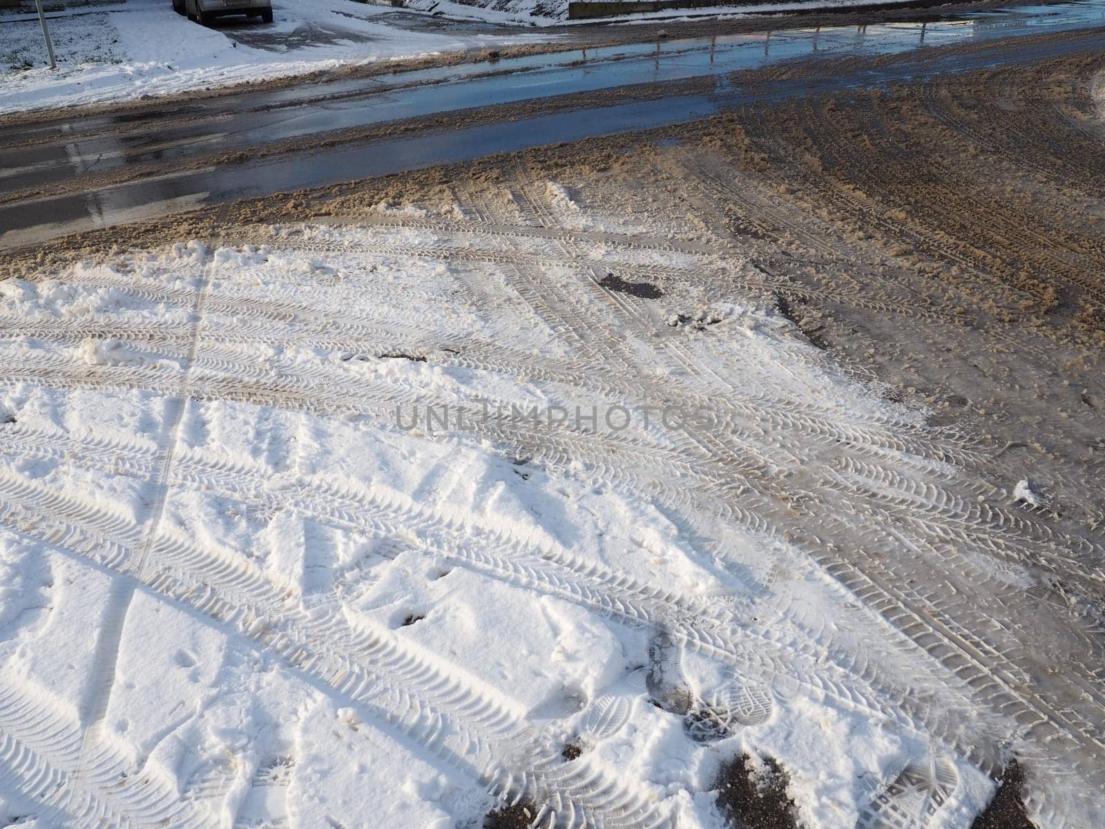 A fork or siding from a roundabout. Snowdrifts on the side of the road. Bad weather and traffic. Snow on asphalt. Difficult driving conditions. Winter slosh on the road. Braking distance of a car.