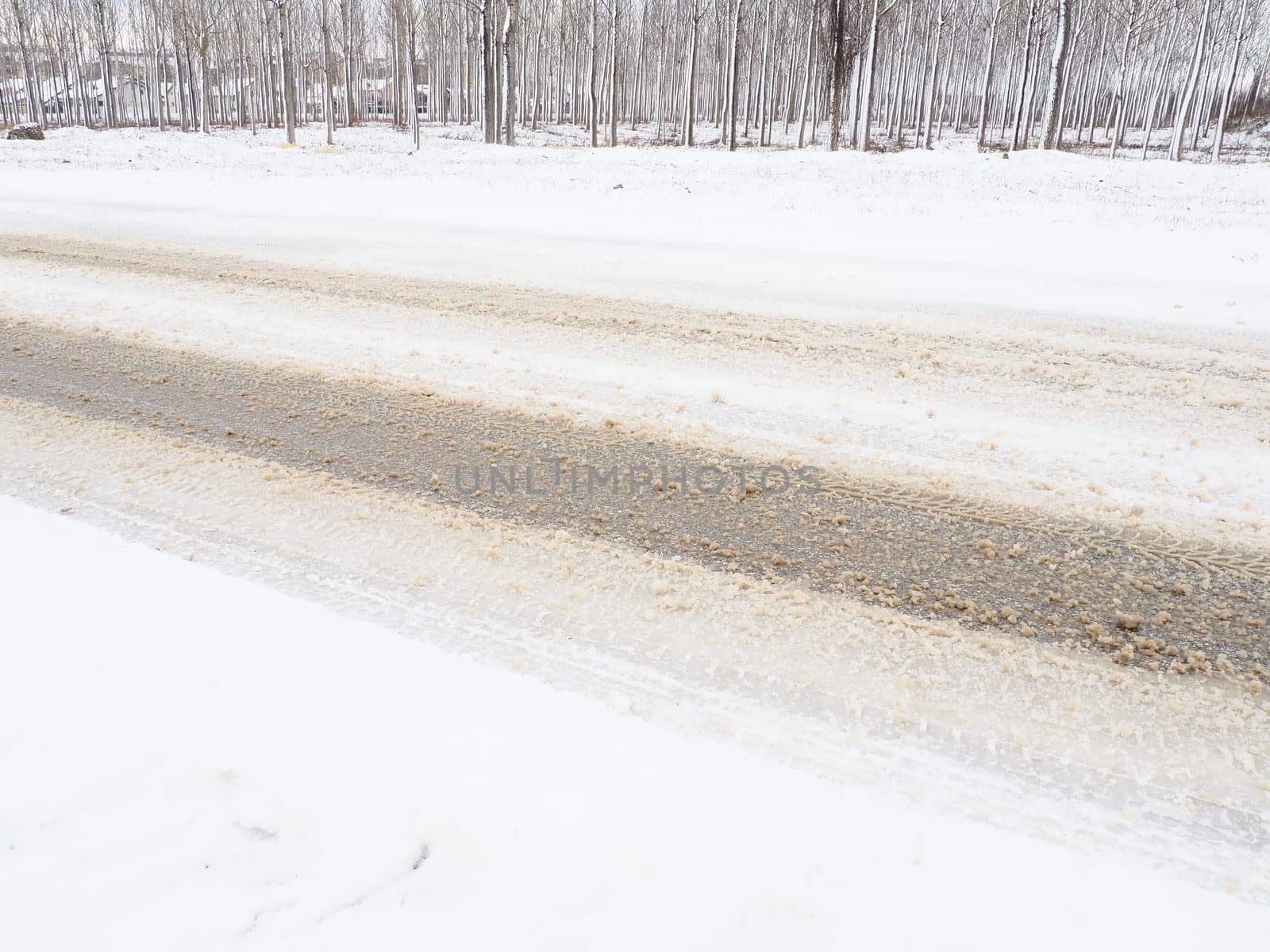 Snowdrifts on the side of the road. Bad weather and traffic. Snow on asphalt. Difficult driving conditions. Winter slosh on the road. Braking distance of a car