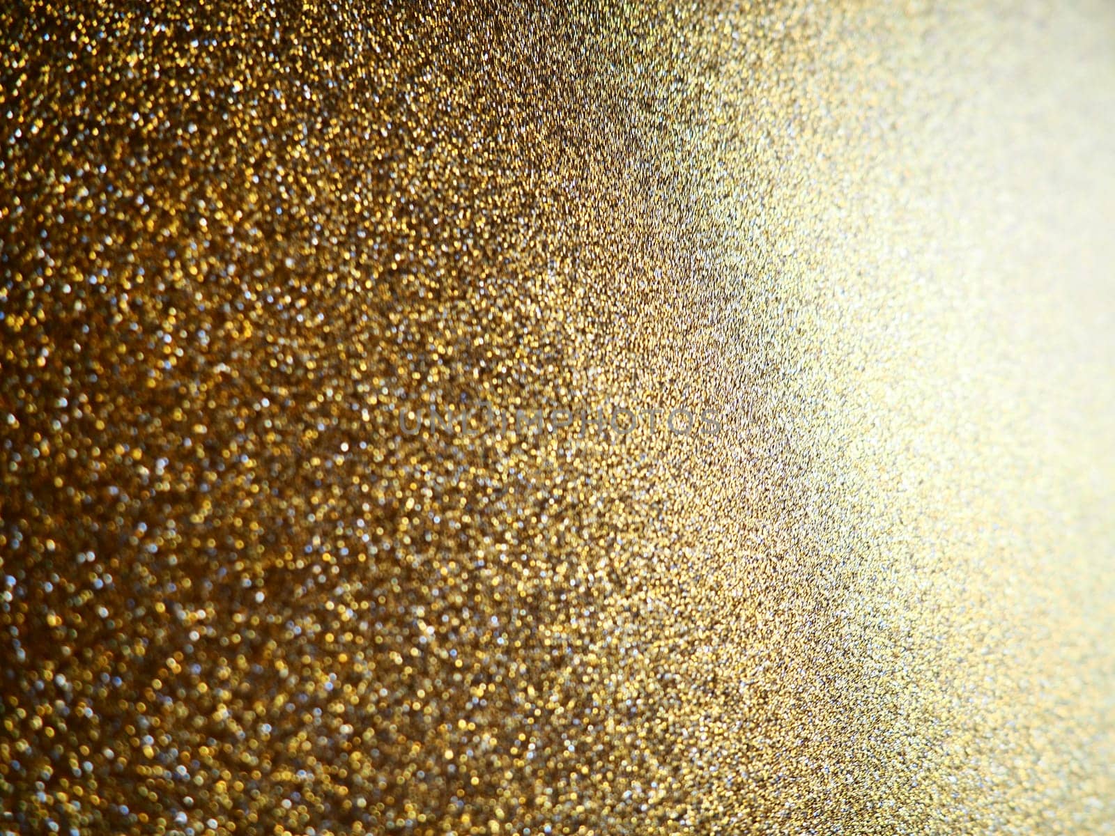 Gold close up. Golden glitter texture background. Sparkling glitter wrapping paper with sequins and sparkles. Festive golden bokeh and glitter. Beautiful background. Bokeh light of gold glitters.