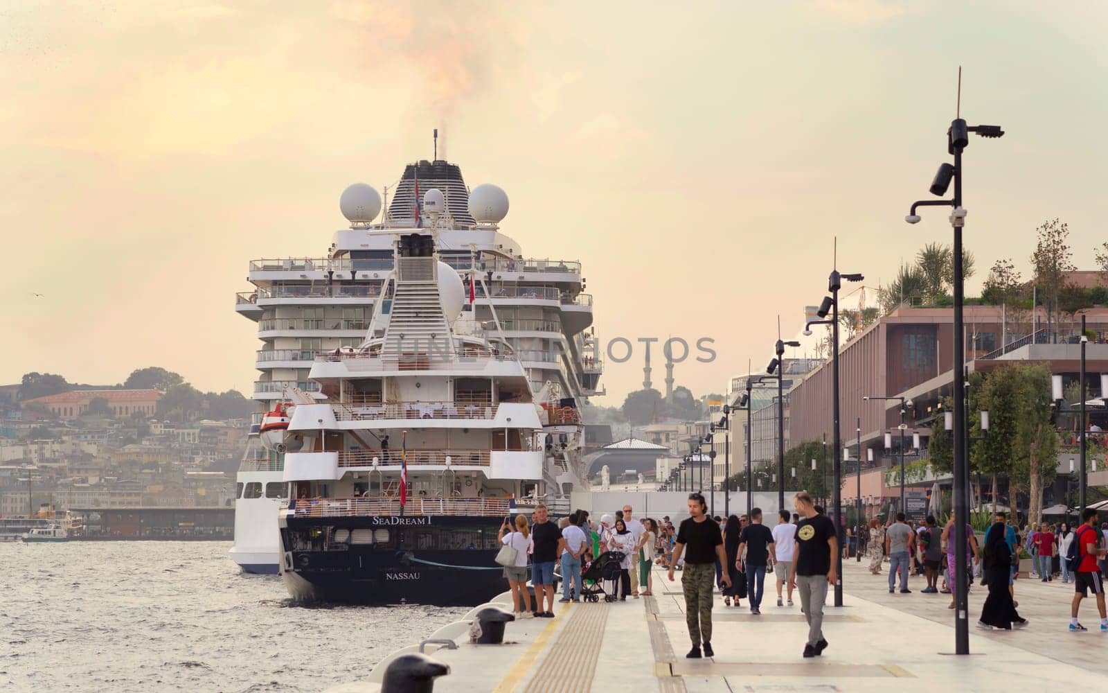 Istanbul, Turkey - August 26, 2022: Galataport , a mixed use development located along shore of Bosphorus strait, in Karakoy neighbourhood, with two large cruises docked, and pedestrians waking