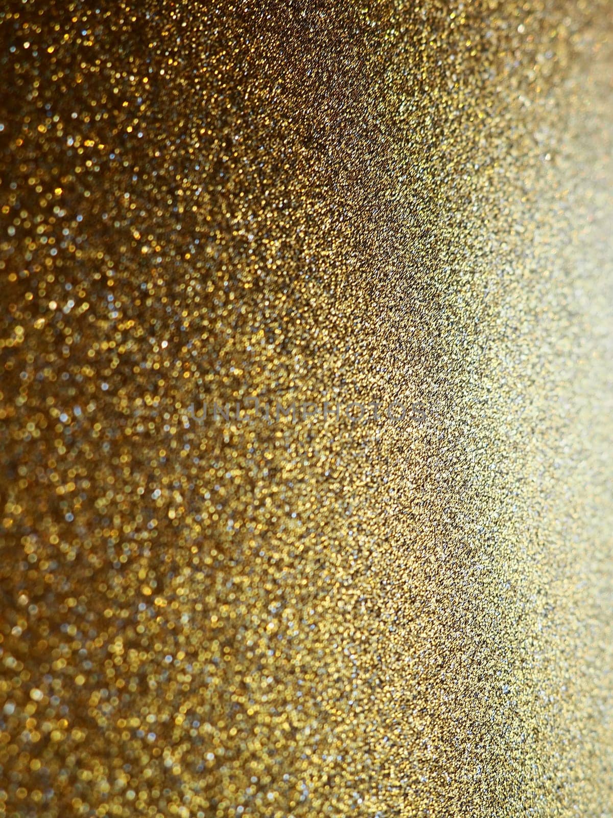 Gold close up. Golden glitter texture background. Sparkling glitter wrapping paper with sequins and sparkles. Festive golden bokeh and glitter. Beautiful background. Bokeh light of gold glitters.