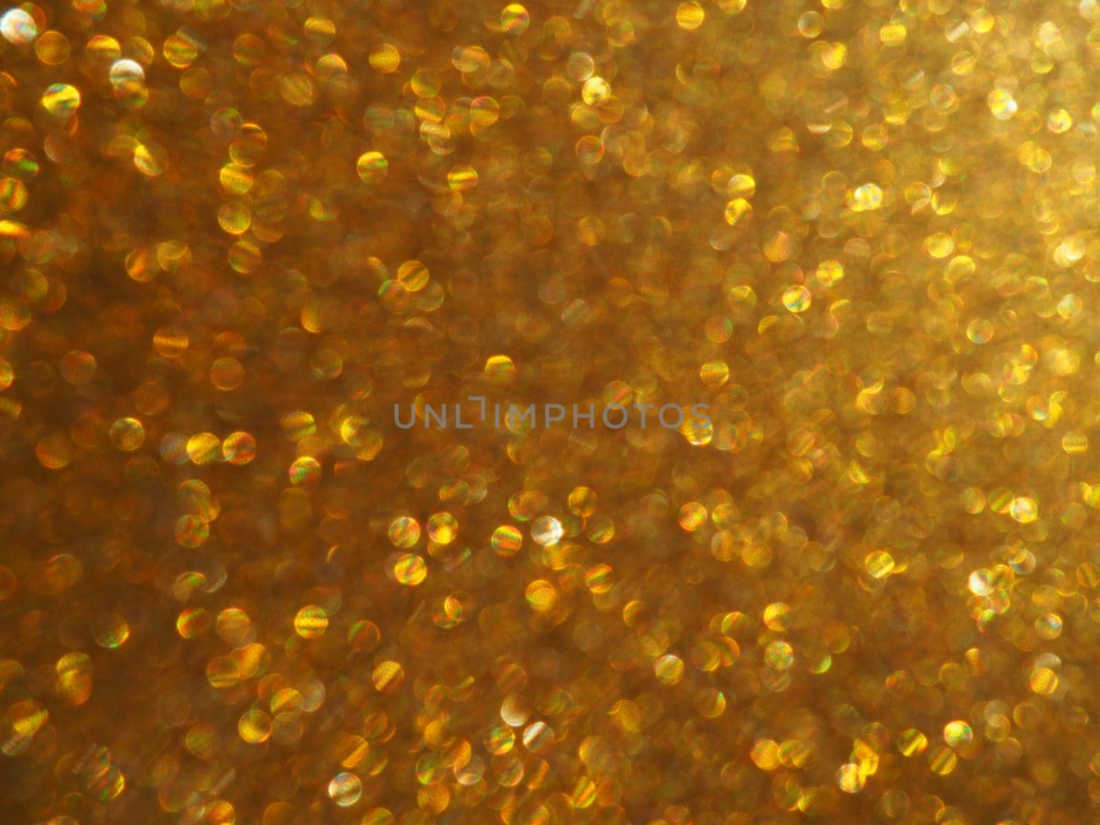 Bokeh light of gold glitters. Golden glitter texture background. Sparkling glitter wrapping paper with sequins and sparkles. Festive golden bokeh and glitter. Beautiful macro background.