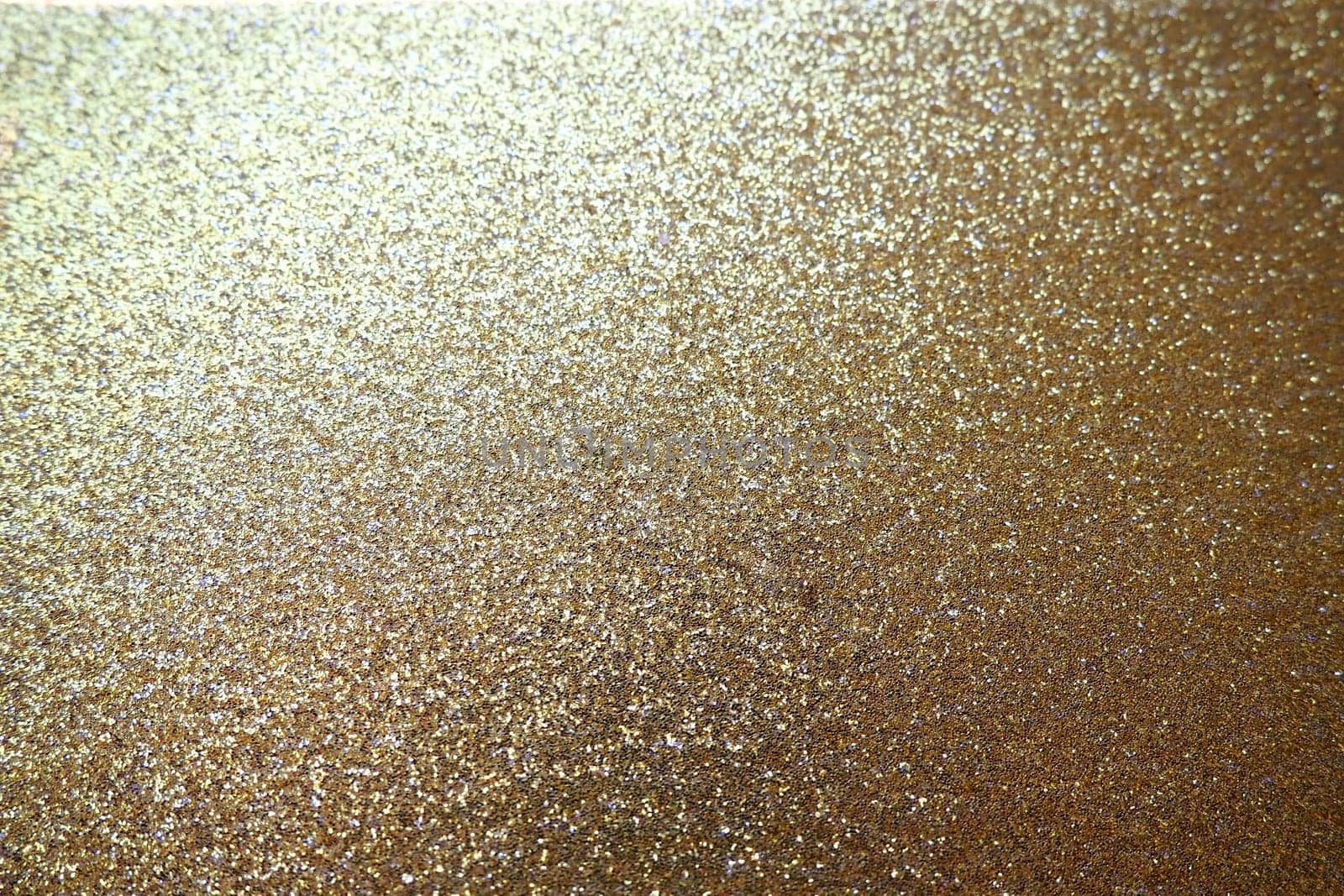 Gold close up. Golden glitter texture background. Sparkling glitter wrapping paper with sequins and sparkles. Festive golden bokeh and glitter. Beautiful background. Bokeh light of gold glitters.