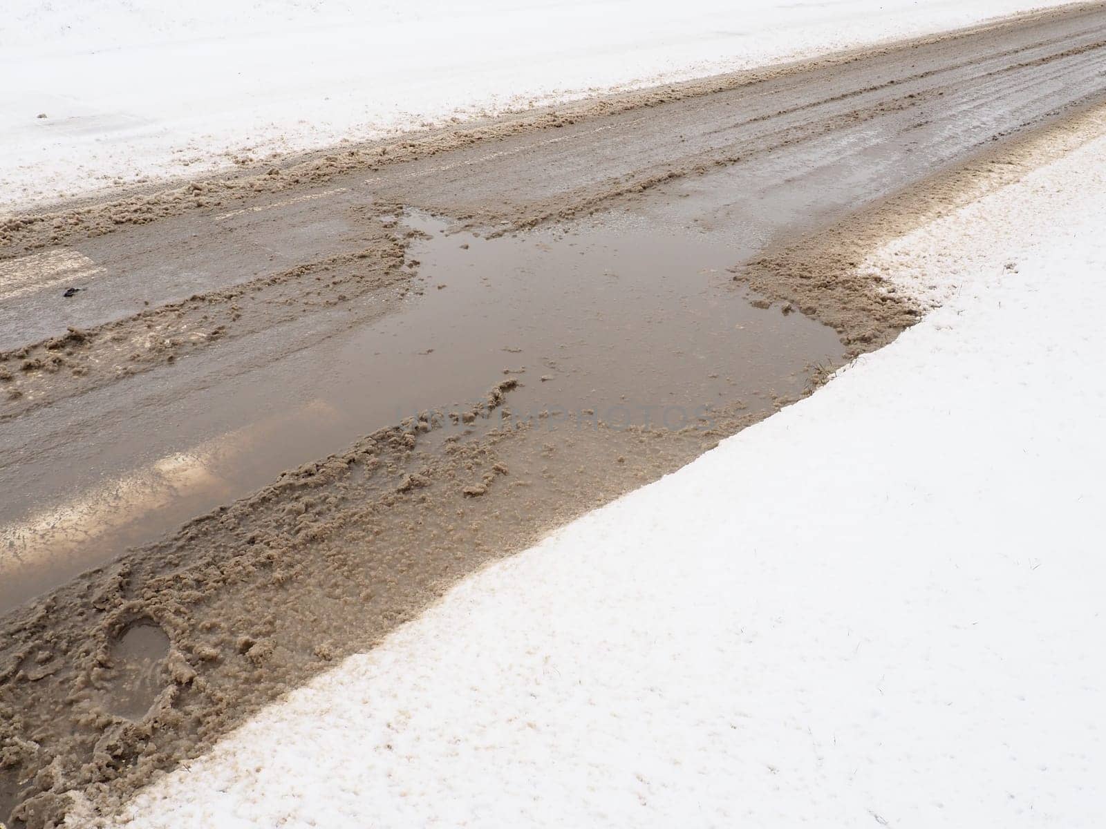 Snow, ice, slush and winter mud at a pedestrian crossing. The air temperature is about 0. Difficult driving conditions. Braking distance of the car. Traffic Laws. Infrastructure and road services.