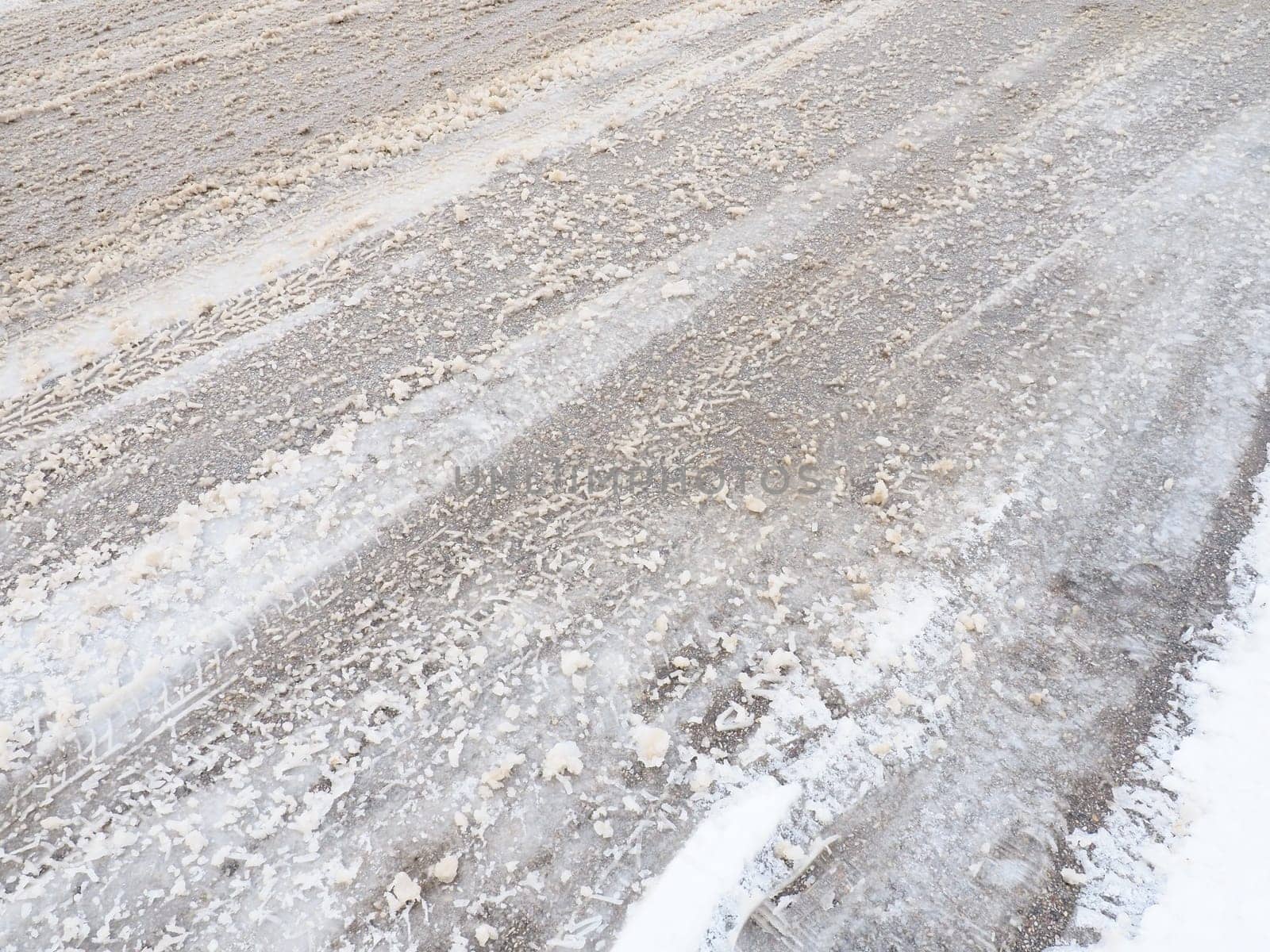 Snowdrifts on the side of the road. Bad weather and traffic. Snow on asphalt. Difficult driving conditions. Winter slosh on the road. Braking distance of a car