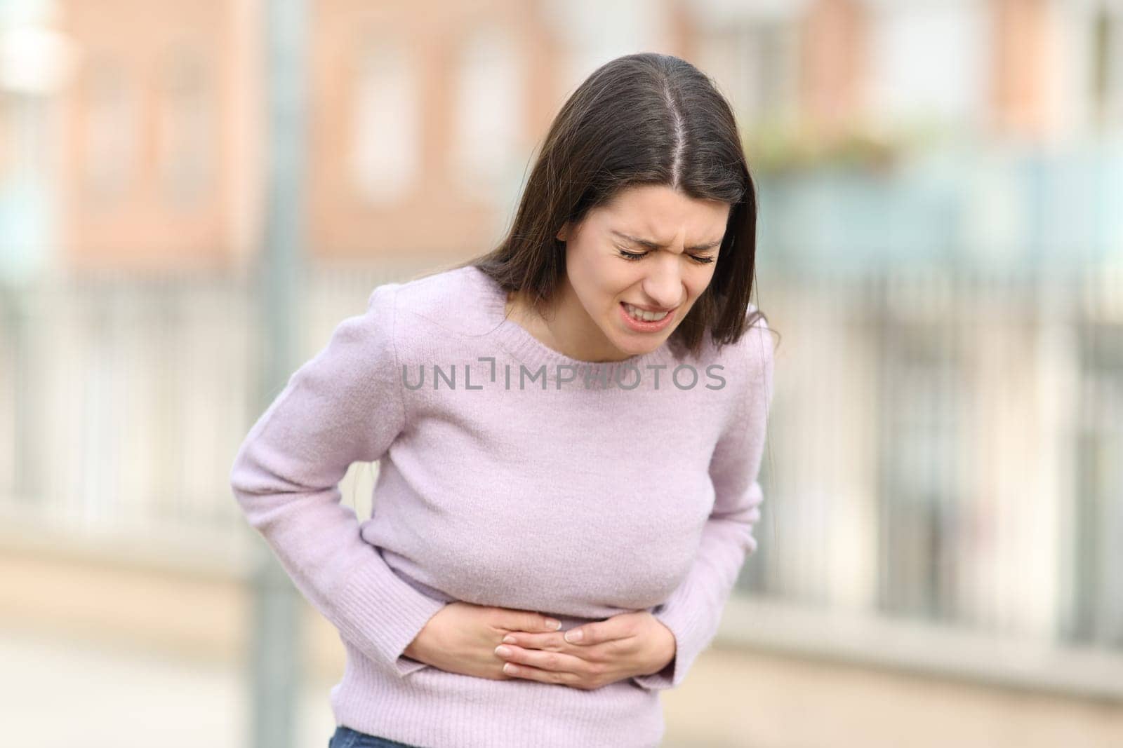 Teen suffering stomach ache in the street