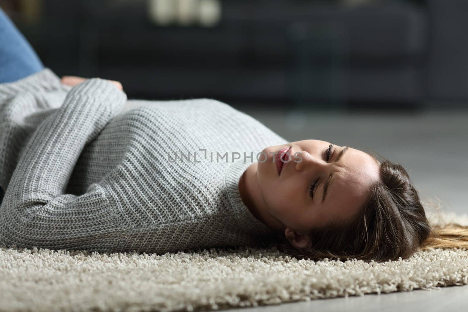 Sad teen lying on the floor at home in the night