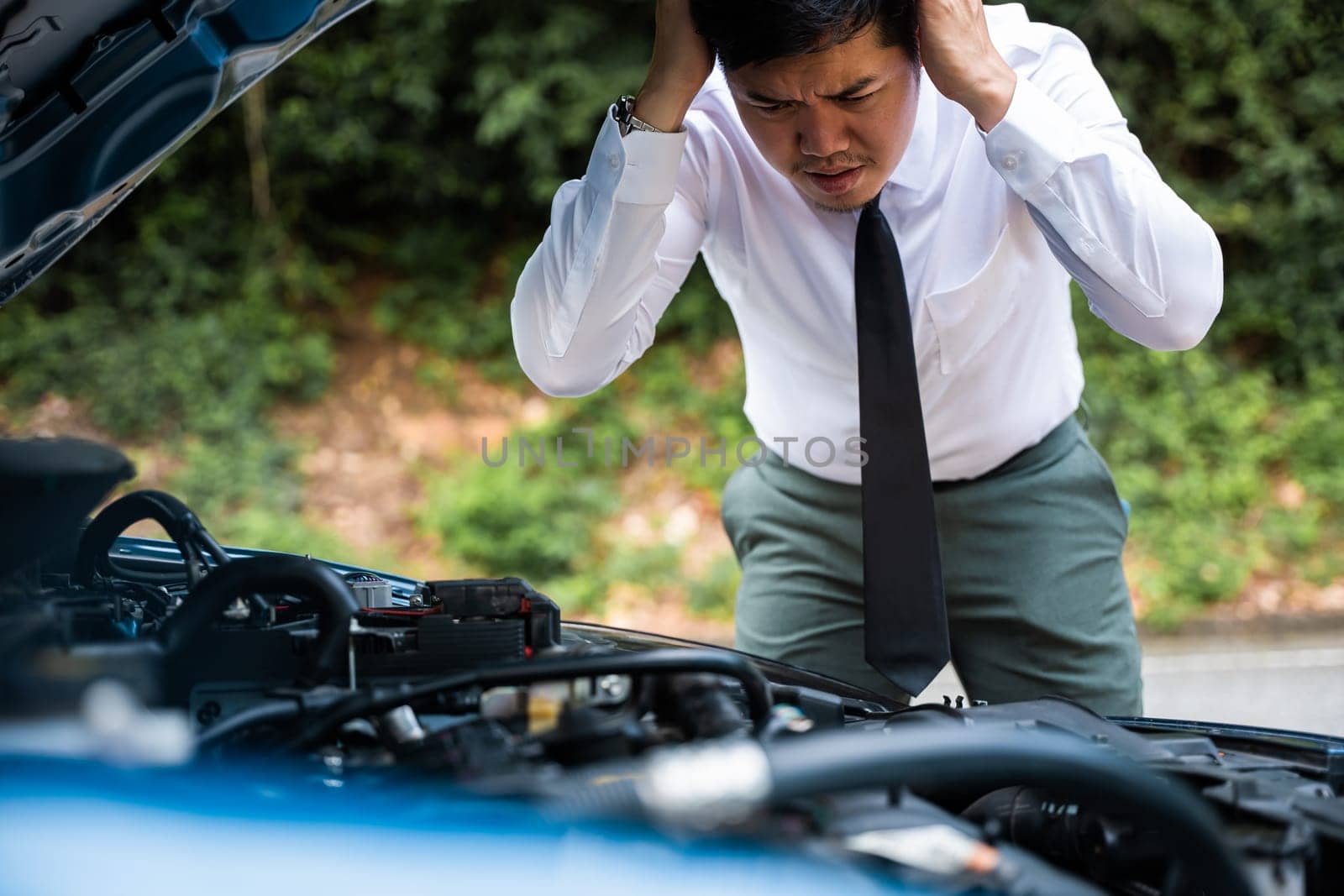 Asian businessman car broken breakdown, young stressed man having trouble car failure problem looking in frustration at failed engine in the morning, accident on road outdoor, late for work