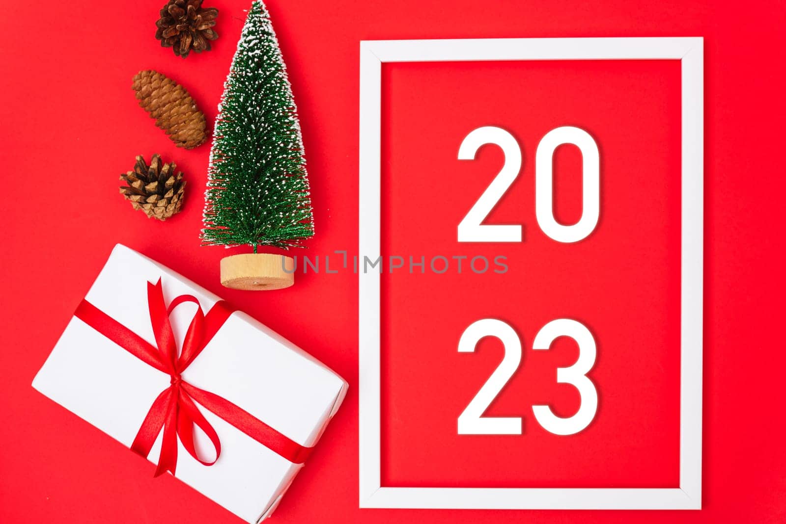 Happy New Year 2023 background. Banner Christmas gifts and decorations with 2023 years number on red background, Flat lay, top view, copy space