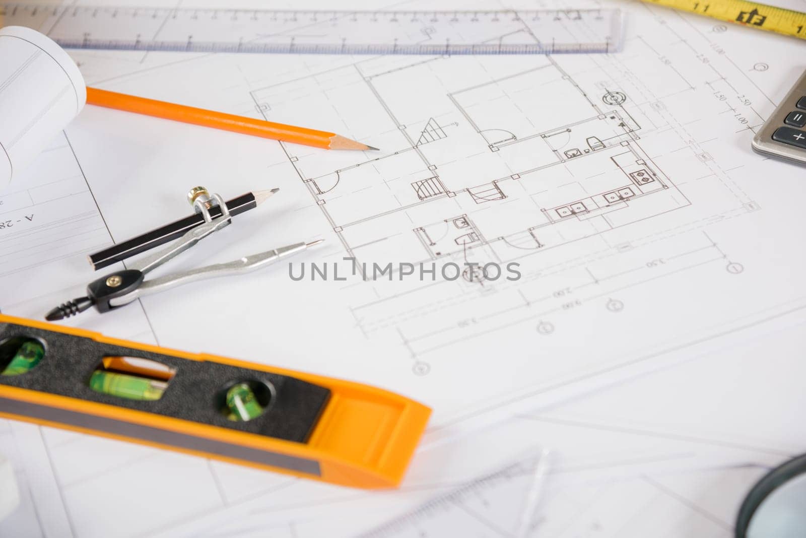 Architectural project workplace. Top view of house plan blueprint paper with repair tools on table desk at architecture office, Engineering architect design tools concept