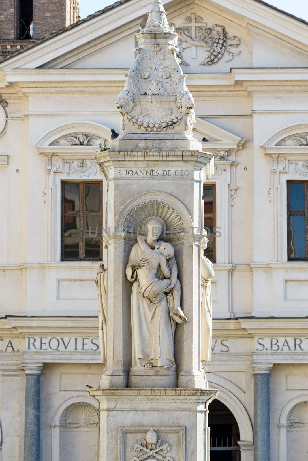 statue and church on the tiberina isle in rome italy