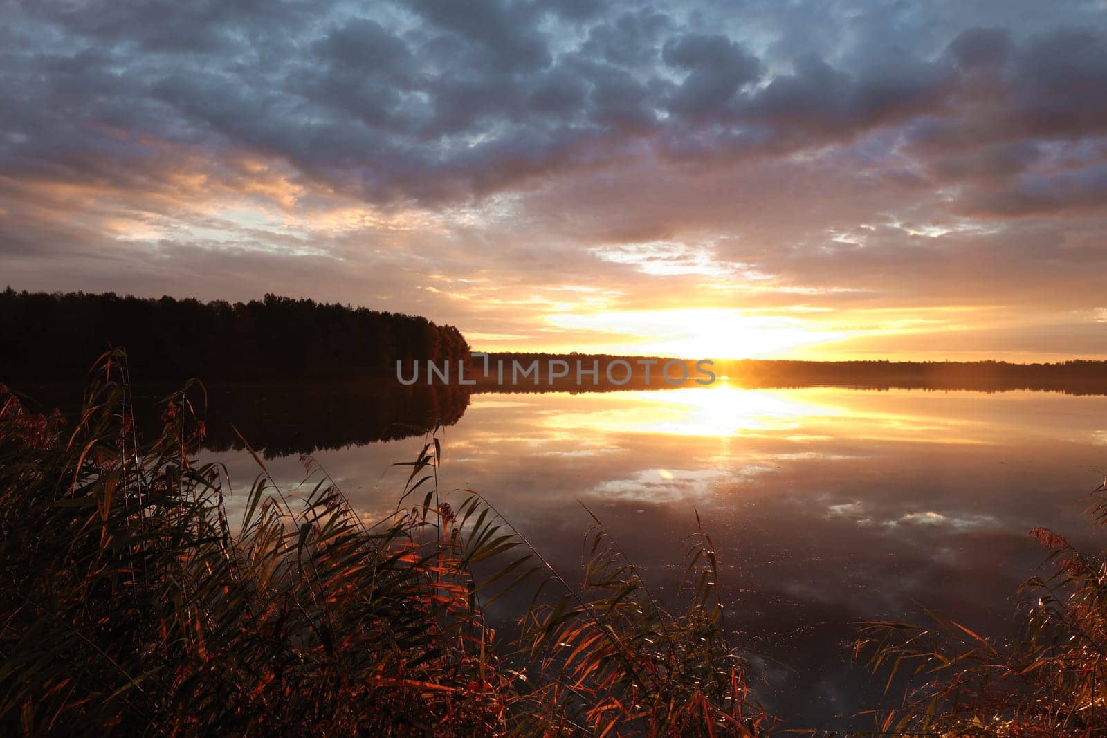 Sunrise over the lake on a cloudy autumn day.