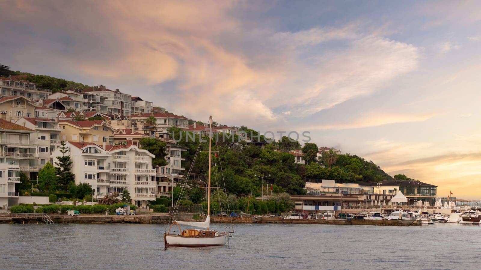 Sailboat with background of the mountains of Kinaliada island from Marmara Sea, with traditional summer houses and boats, and Istanbul, Turkey
