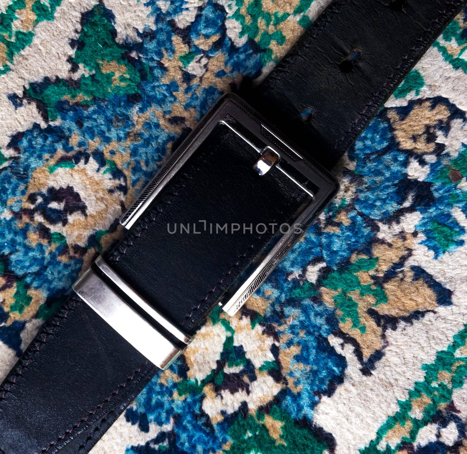 Black men`s belt stylish, placed on a carpeted.
