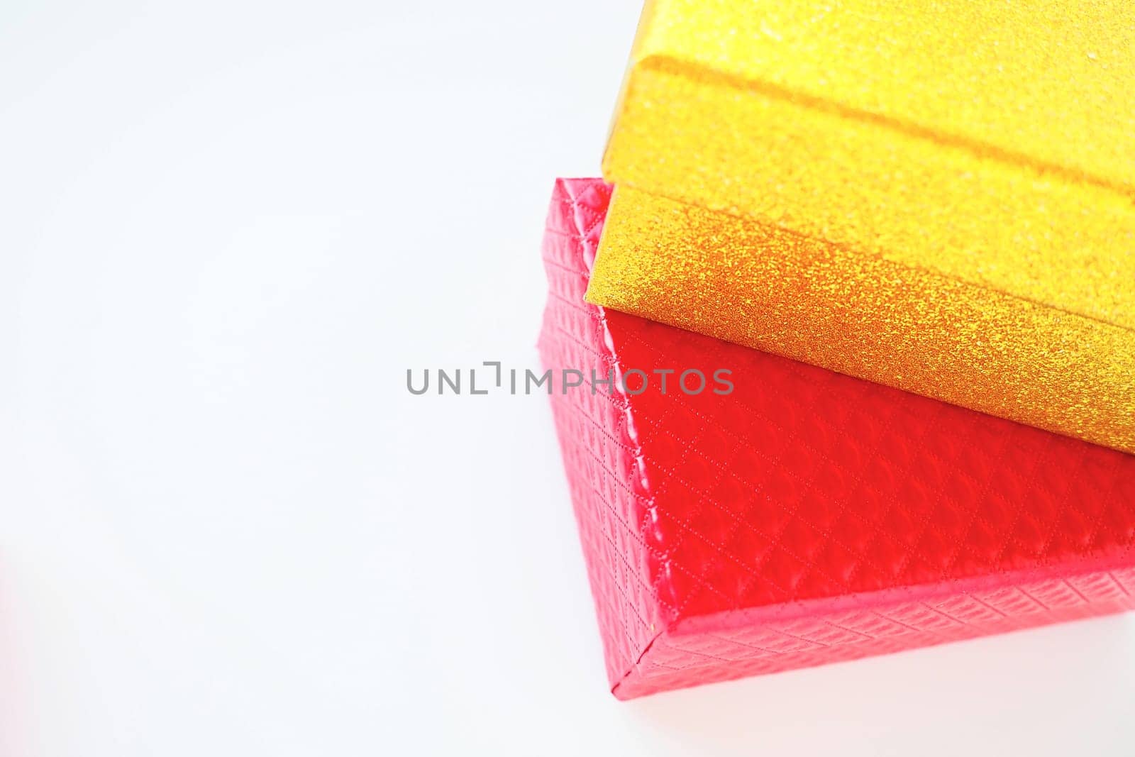 Golden and pink gift boxes on a white background. Decorative holiday box-surprise. Copy space.
