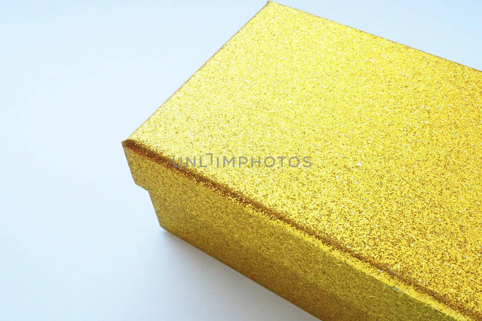 Golden gift box on white background. Decorative surprise box. Copy space.