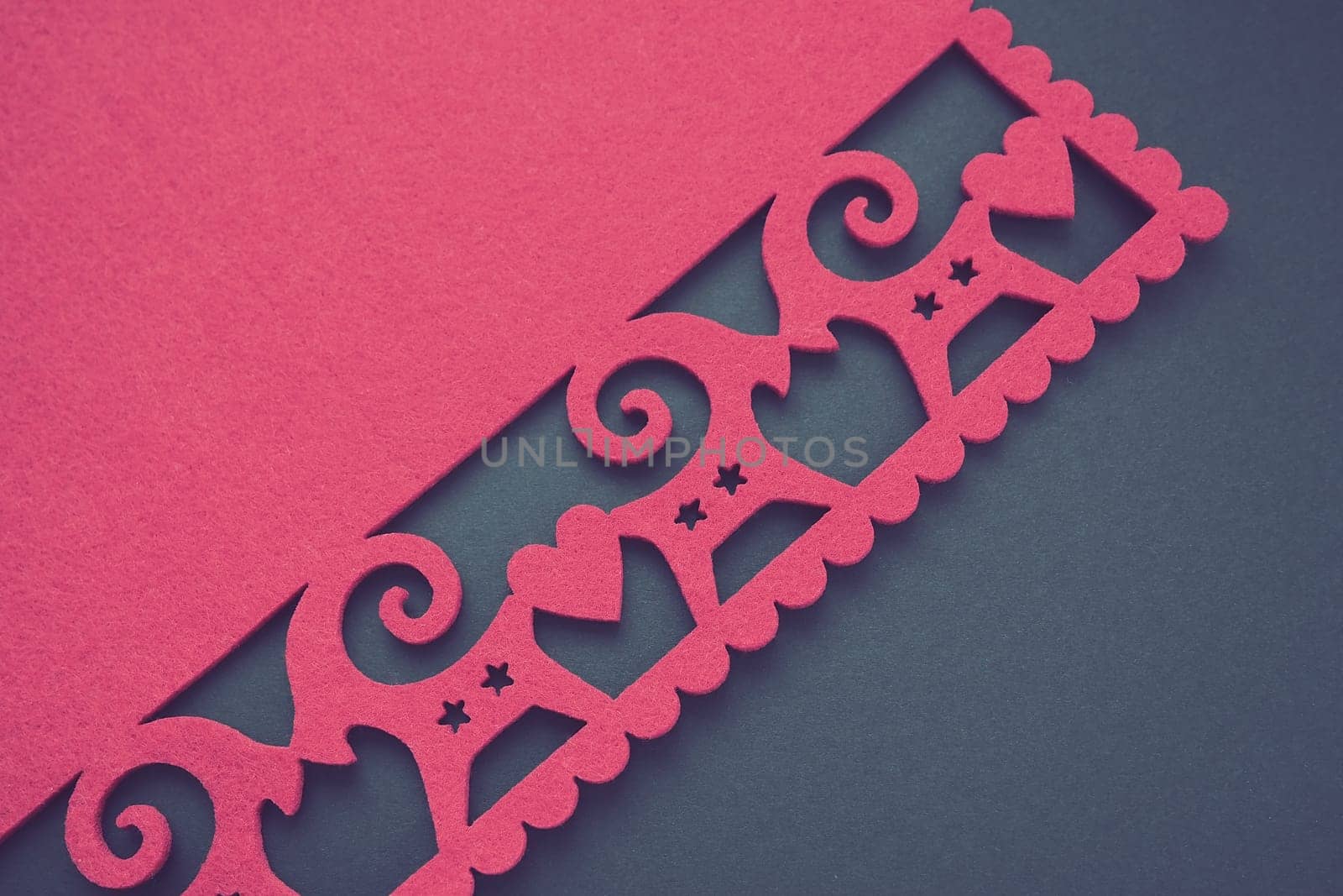 Background New Year's or for Valentine's Day. Kissing goats with stars and hearts are carved on red felt fabric. Merry Christmas and Happy New Year. Postcard, congratulation or invitation. Copy space.