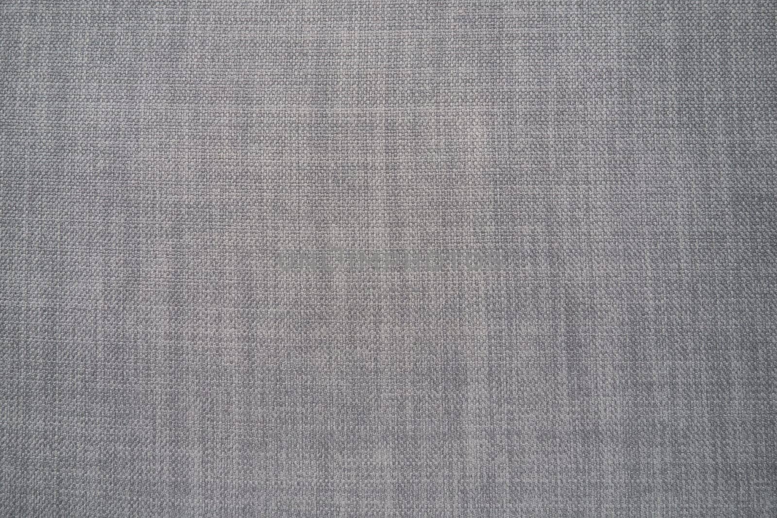 gray background fabric texture. A piece of woolen cloth is neatly laid out on the surface. Weave and textile texture. Dress fabric or for kitchen needs, tablecloth or curtains, close-up. Dash.
