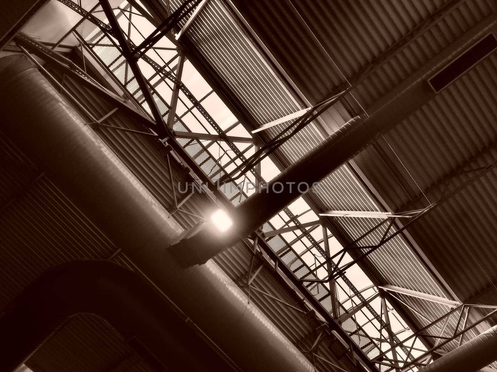 The roof of a hangar, a production hall or a sports hall. Metal structures, beams, supporting elements. Ventilation systems in large halls and rooms. Skylights. Industrial interior