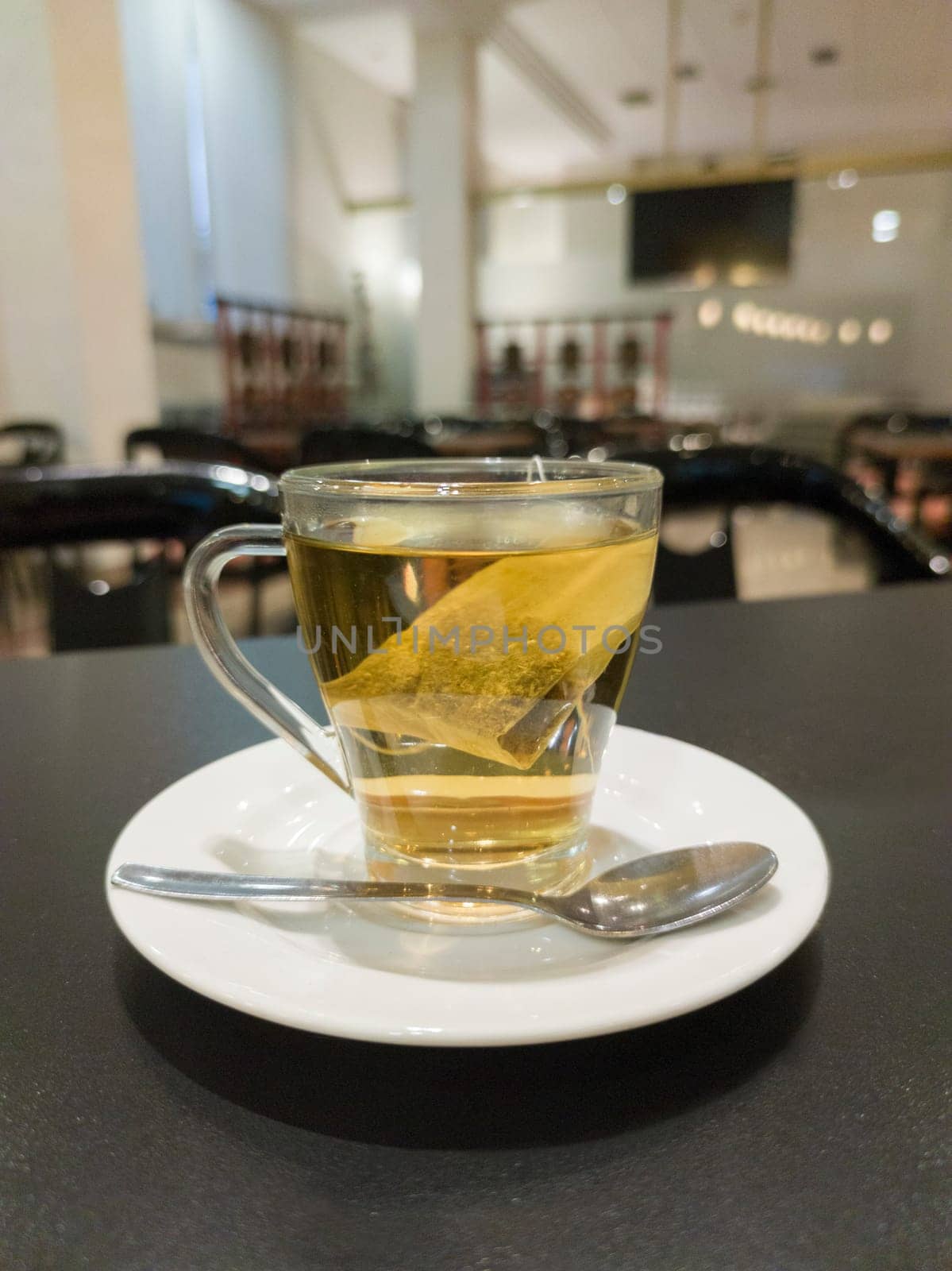 Hot chamomile tea glass cup over restaurant table. Selective focus