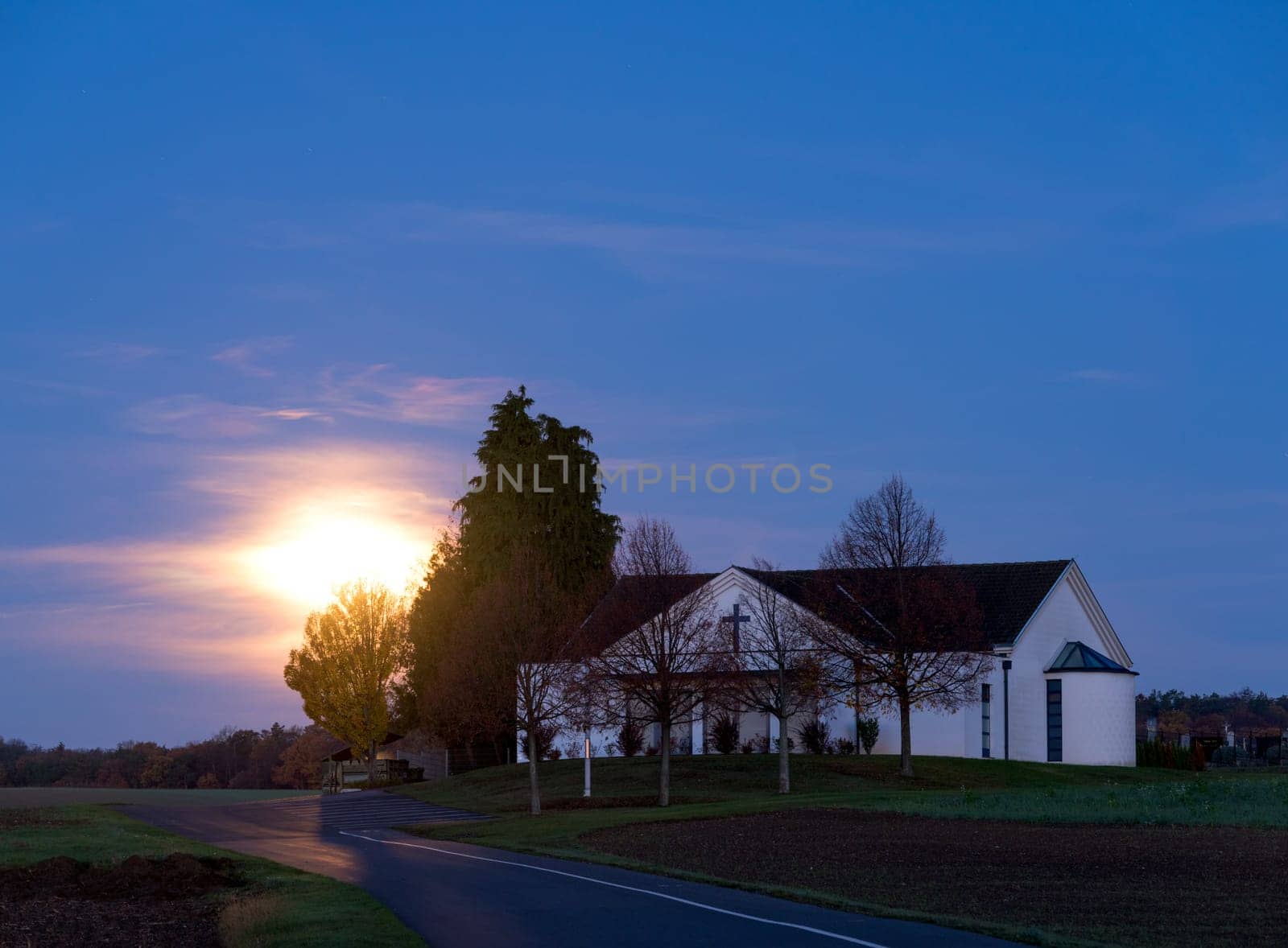 Moon setting over ceremonial hall of a village in Burgenland