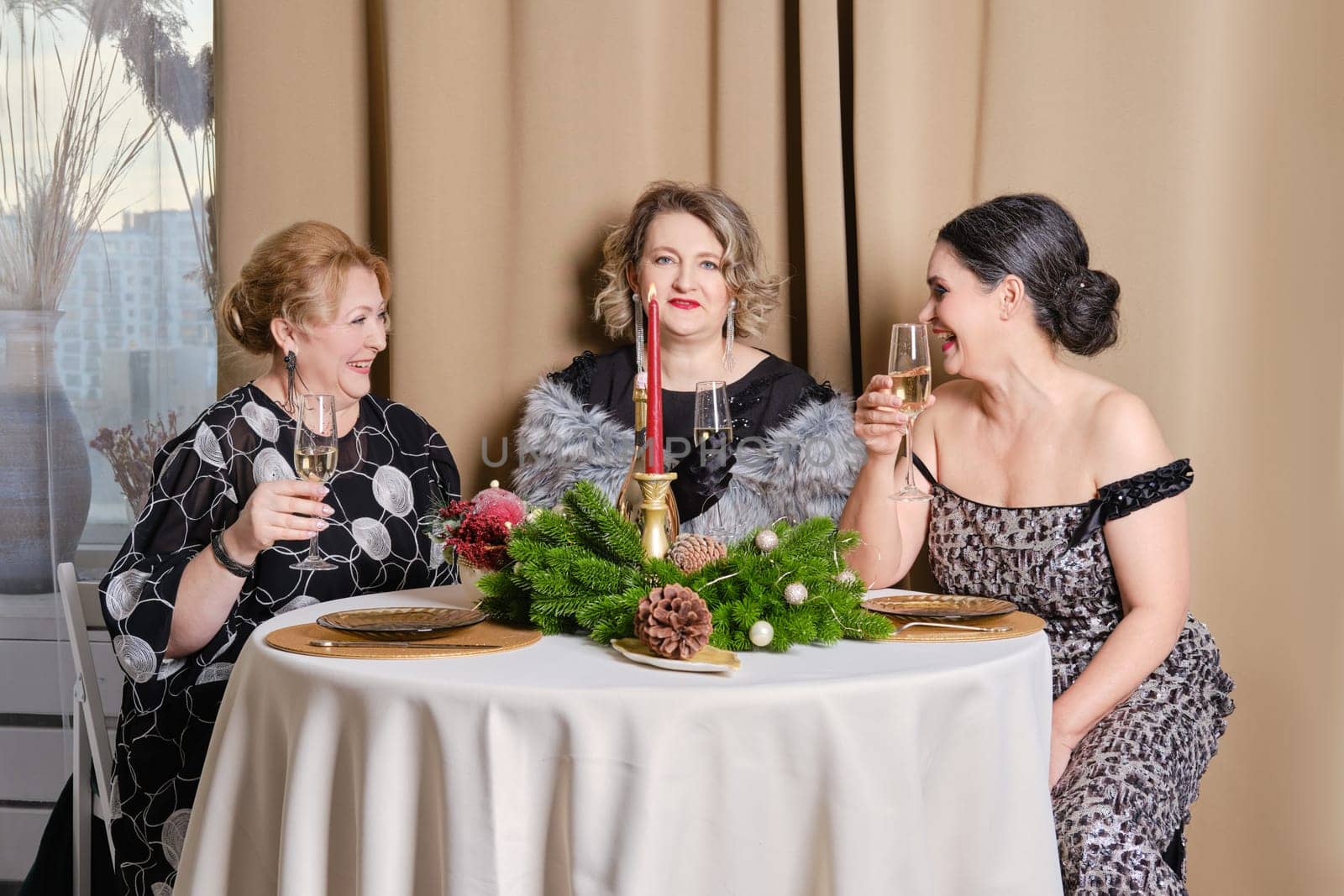 Three joyful middle age women celebrating christmas