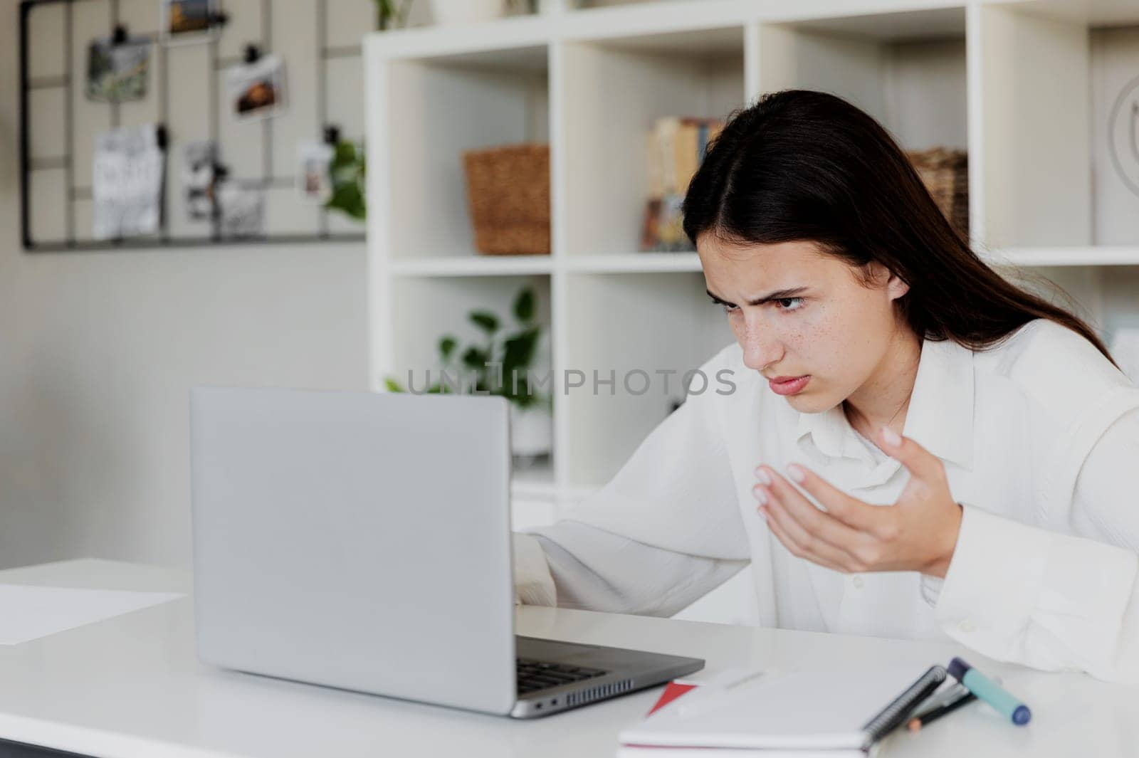 Angry young woman at home office desk work online on computer, have problems with device. Unhappy confused female distressed with laptop troubles, looks desperately, credit card issues while shopping