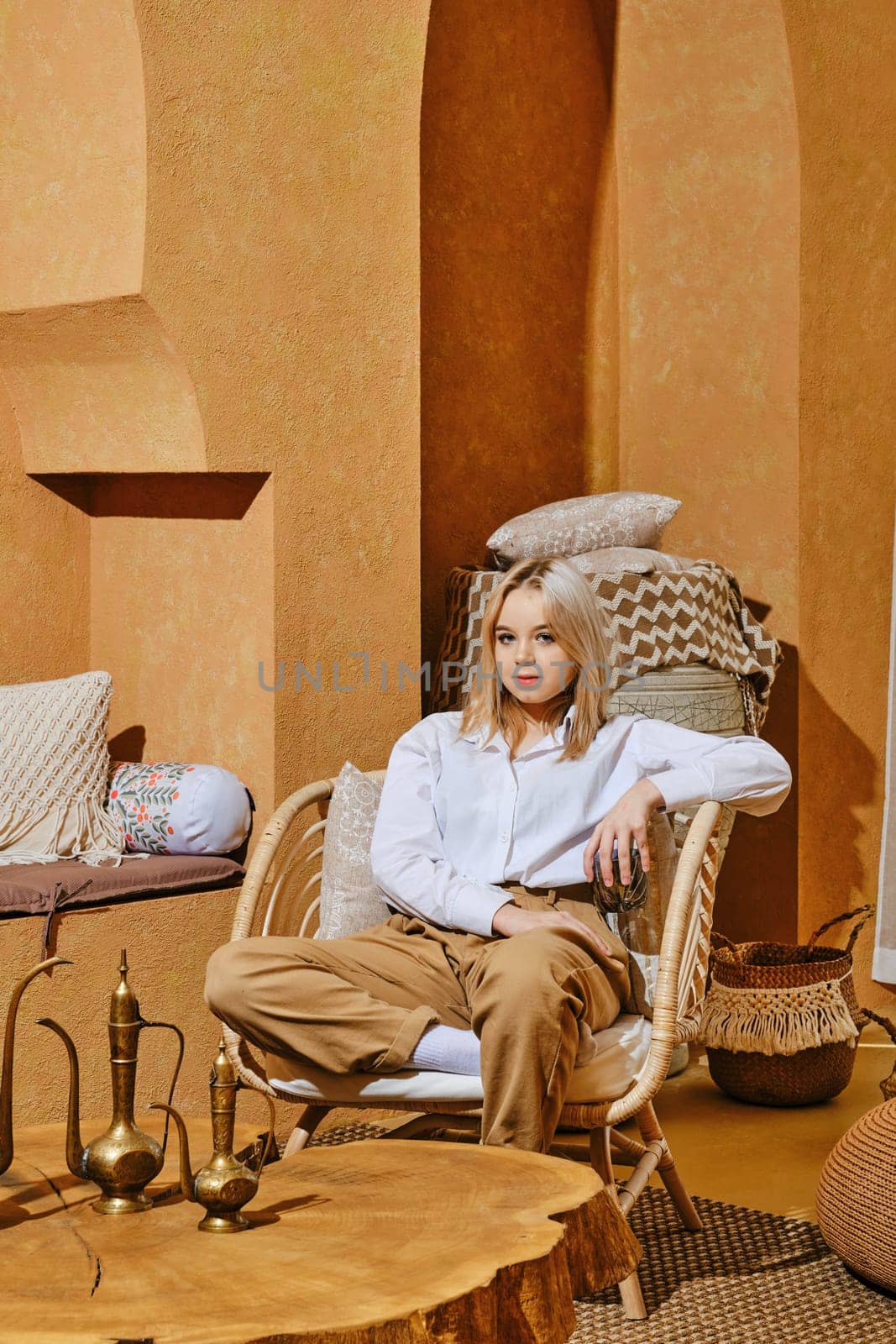Careless young girl rest in wicker armchair in Middle Eastern style room