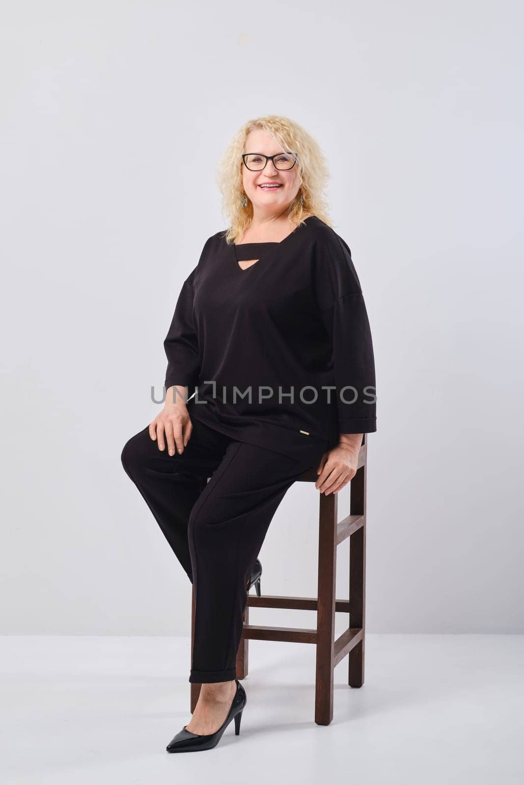 Happy middle age woman in black outfit, studio shot