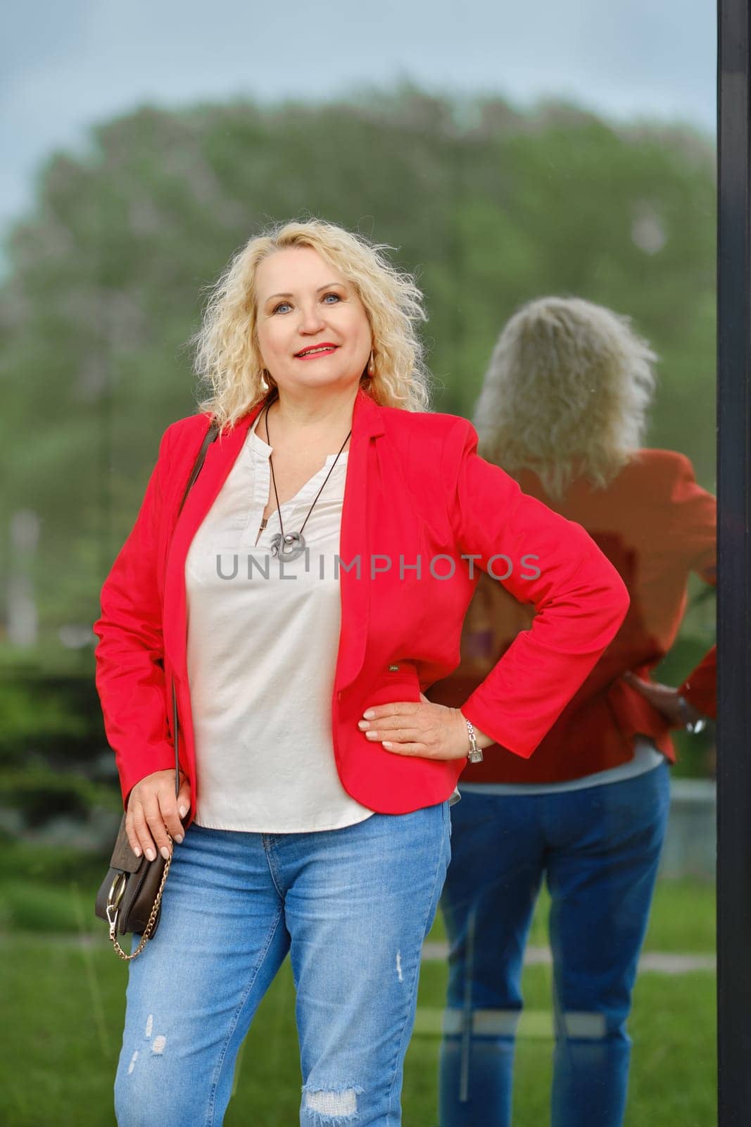 Real estate female agent stands near the reinforced glass wall of the building
