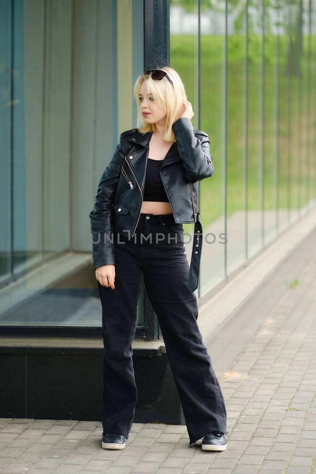 Young teenager model in black clothes and sunglasses outdoors