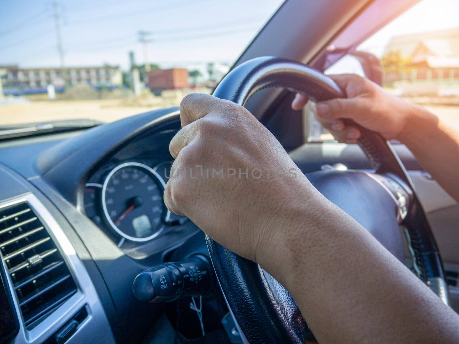 A man's hand held the steering wheel of a car to steer while the car was moving away. Concept and direction of business operations according to the plan. Direction control concept.