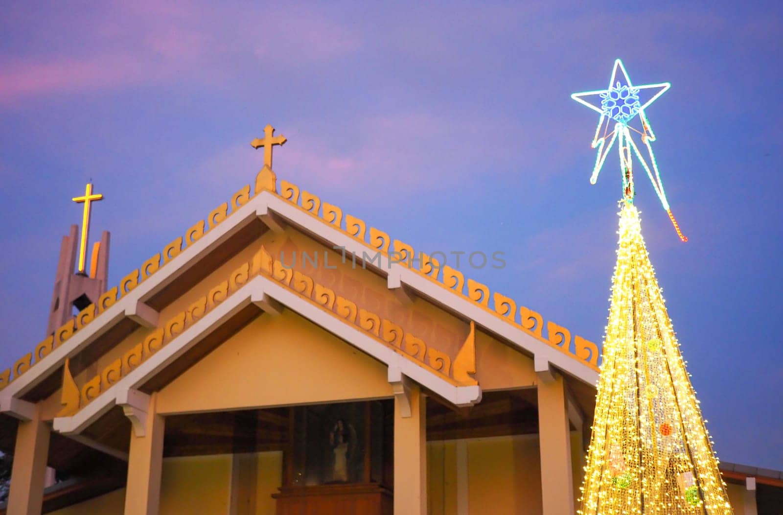 Catholic church with Christmas tree and lights at night