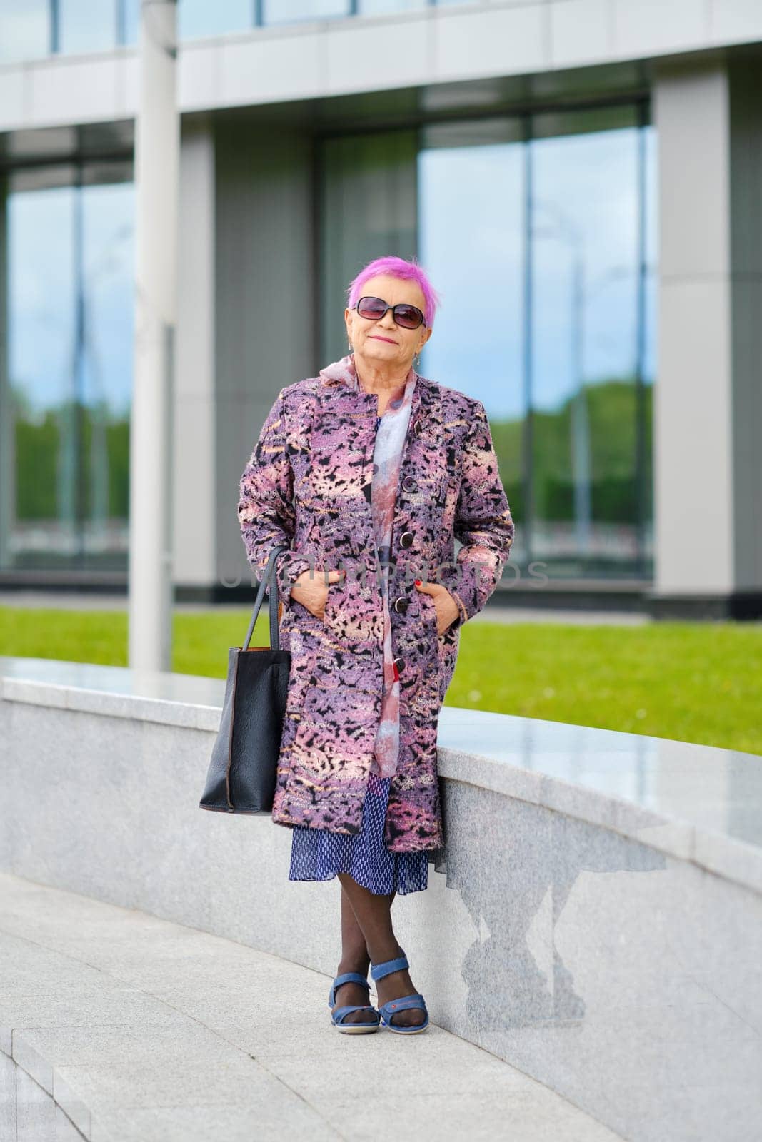 Portrait of a senior woman with pink hair and in cashmere coat taking a walk