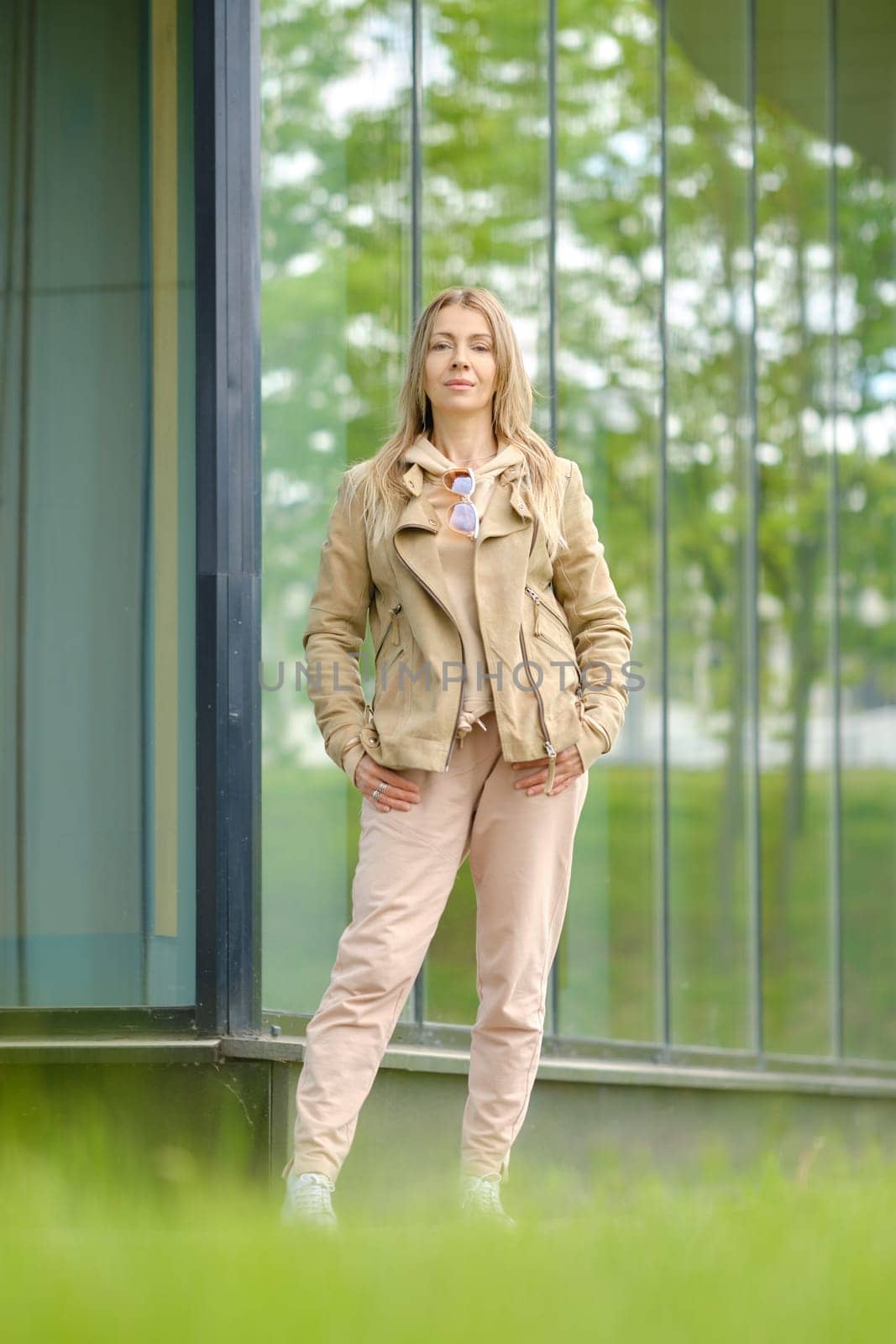 Sporty woman in track suit stands near the reinforced glass wall of her condo