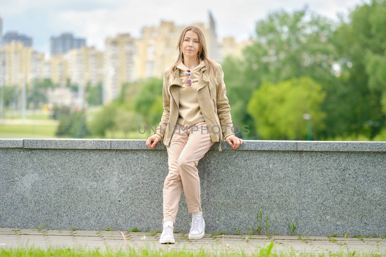Sportive middle aged woman sitting on an embankment