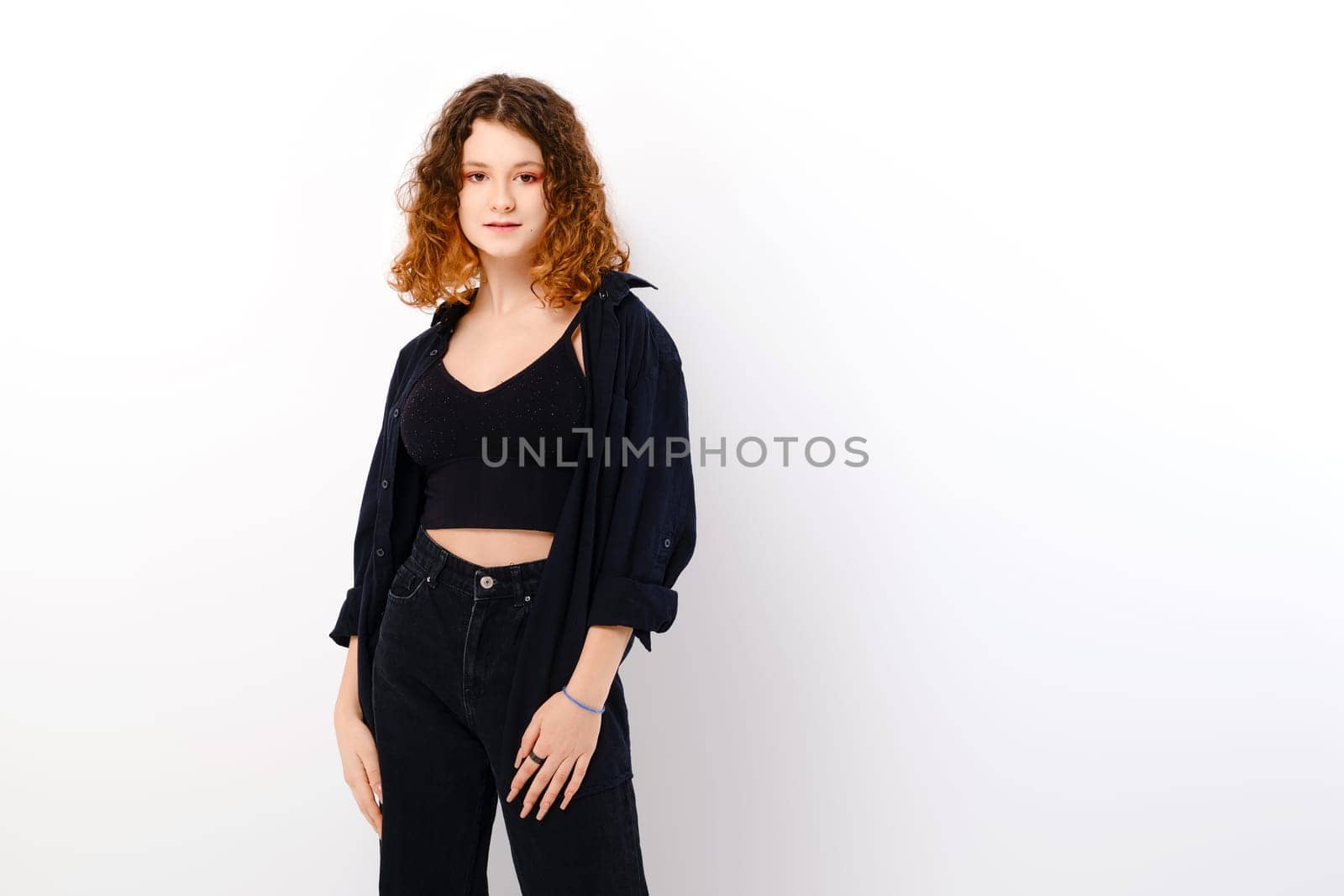 Beautiful teenage girl in casual clothing with colored ends of hair wearing black tank top and shirt over white studio background