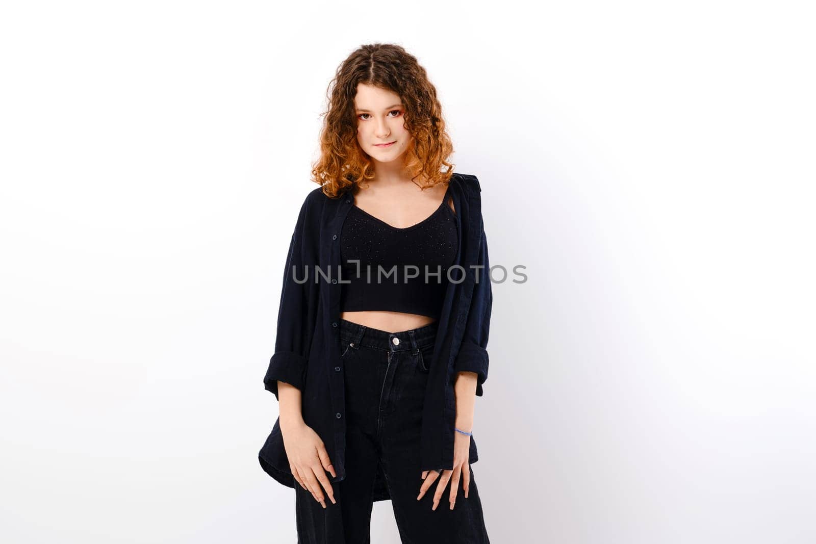 Tricky teenage girl in casual clothing with colored ends of hair looks with a smile