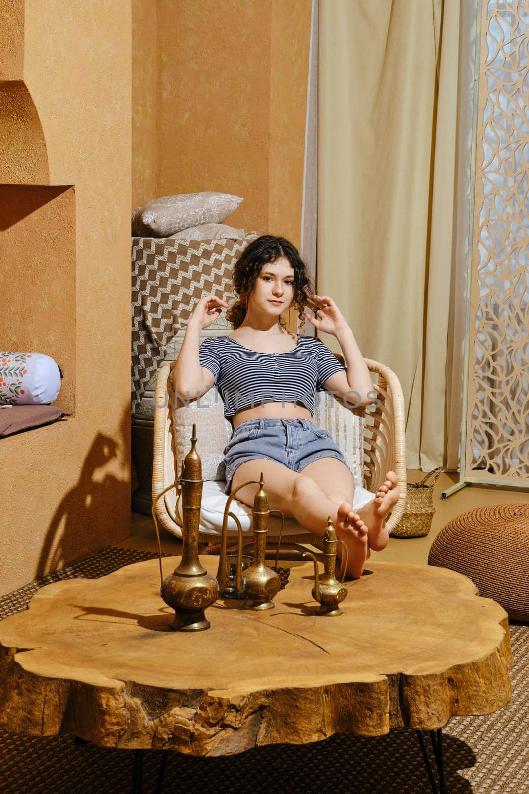 Careless young girl rest in wicker armchair Middle Eastern style room