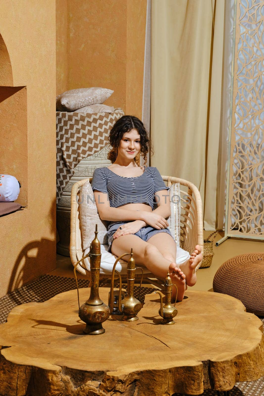 Careless young girl rest in wicker armchair in Middle Eastern style room