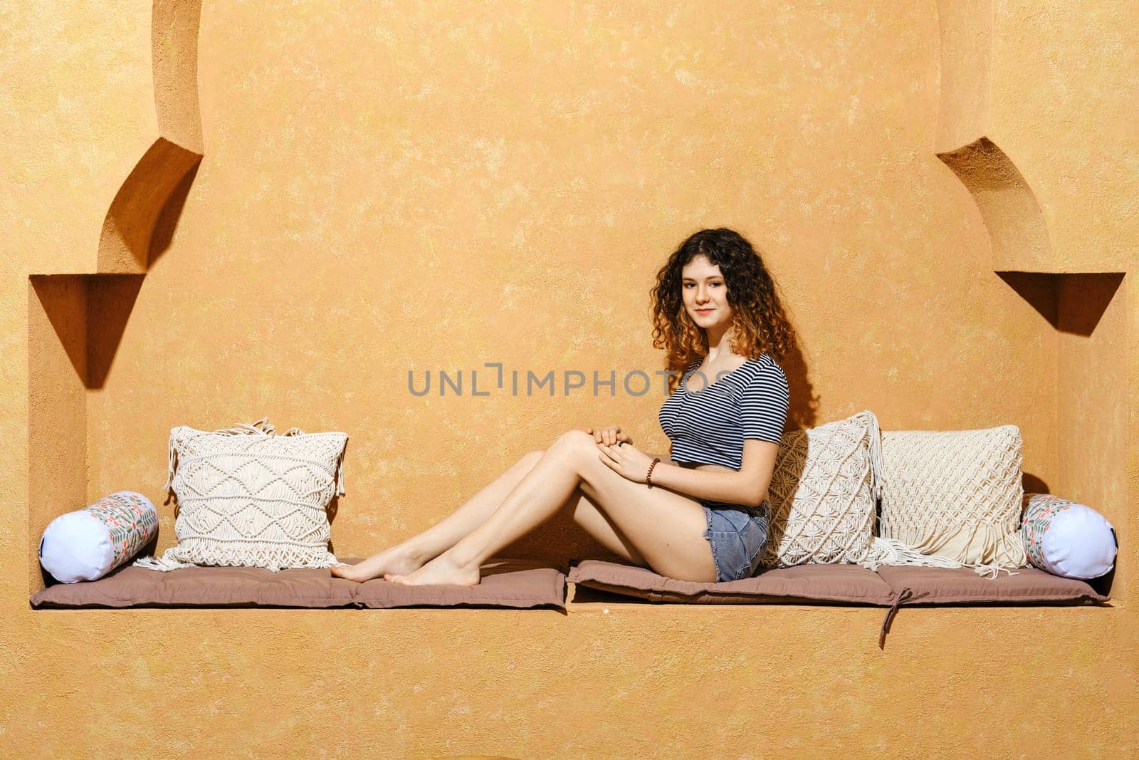 Careless young girl having rest in comfortable Middle Eastern style hotel