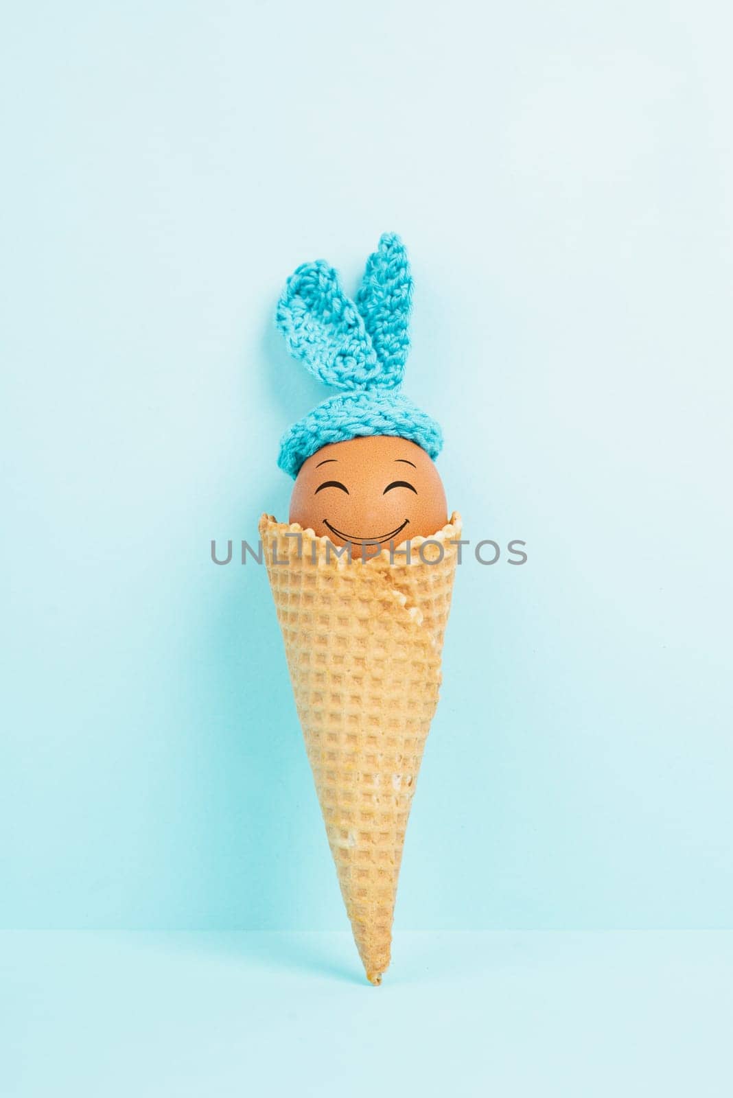 Cute easter bunny or rabbit with a smiling egg face in an ice cream cone, spring holiday, greeting card