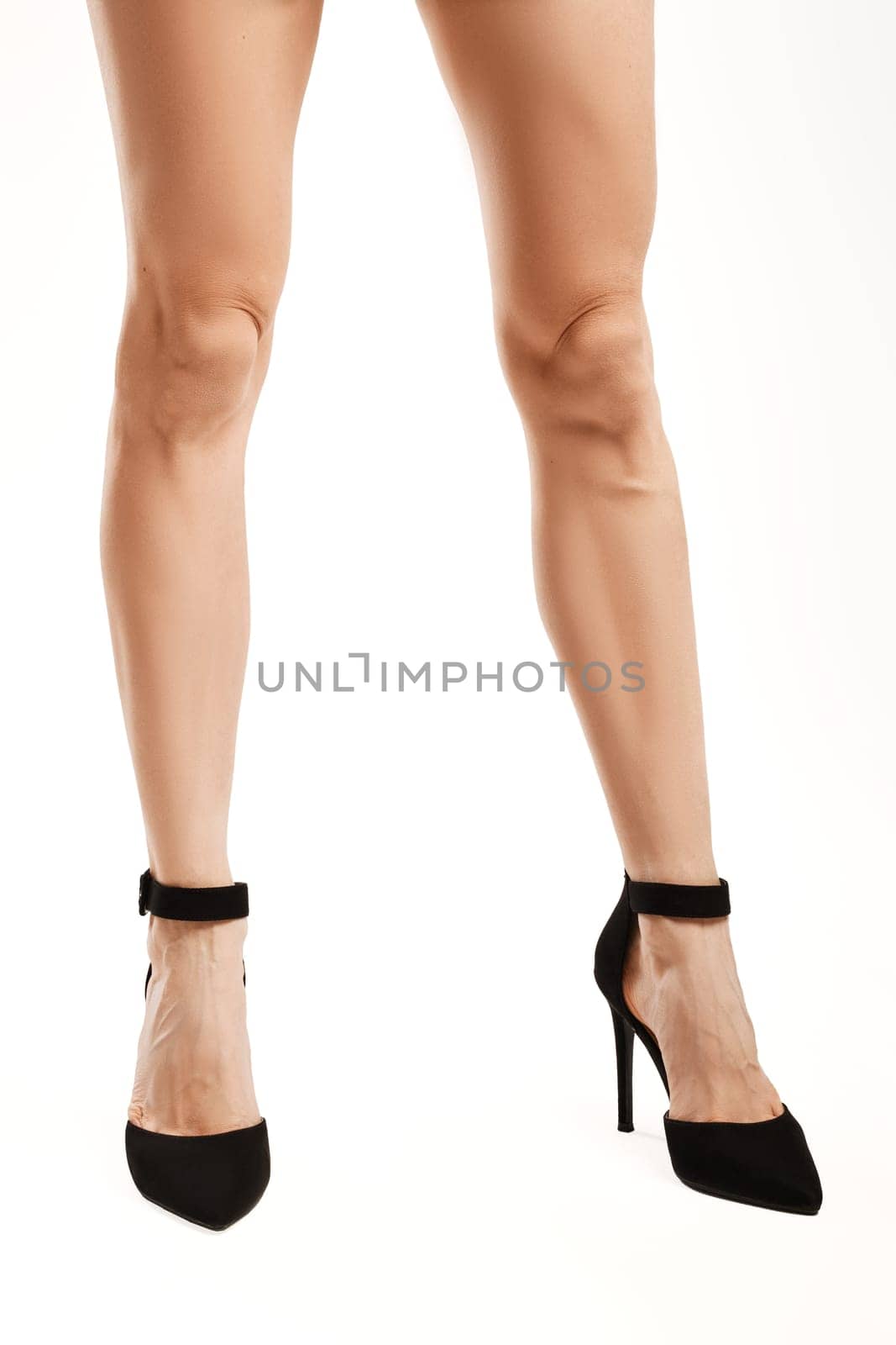 Female legs in high heel suede shoes
