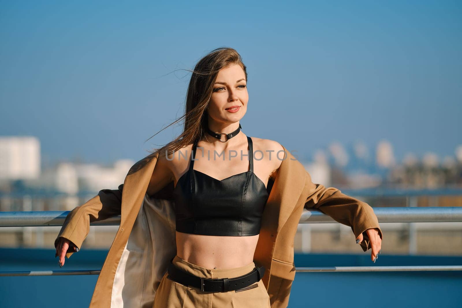 Street fashion, women casual and trendy outfit. Woman in pantsuit, leather tank-top and rough boots outdoor.