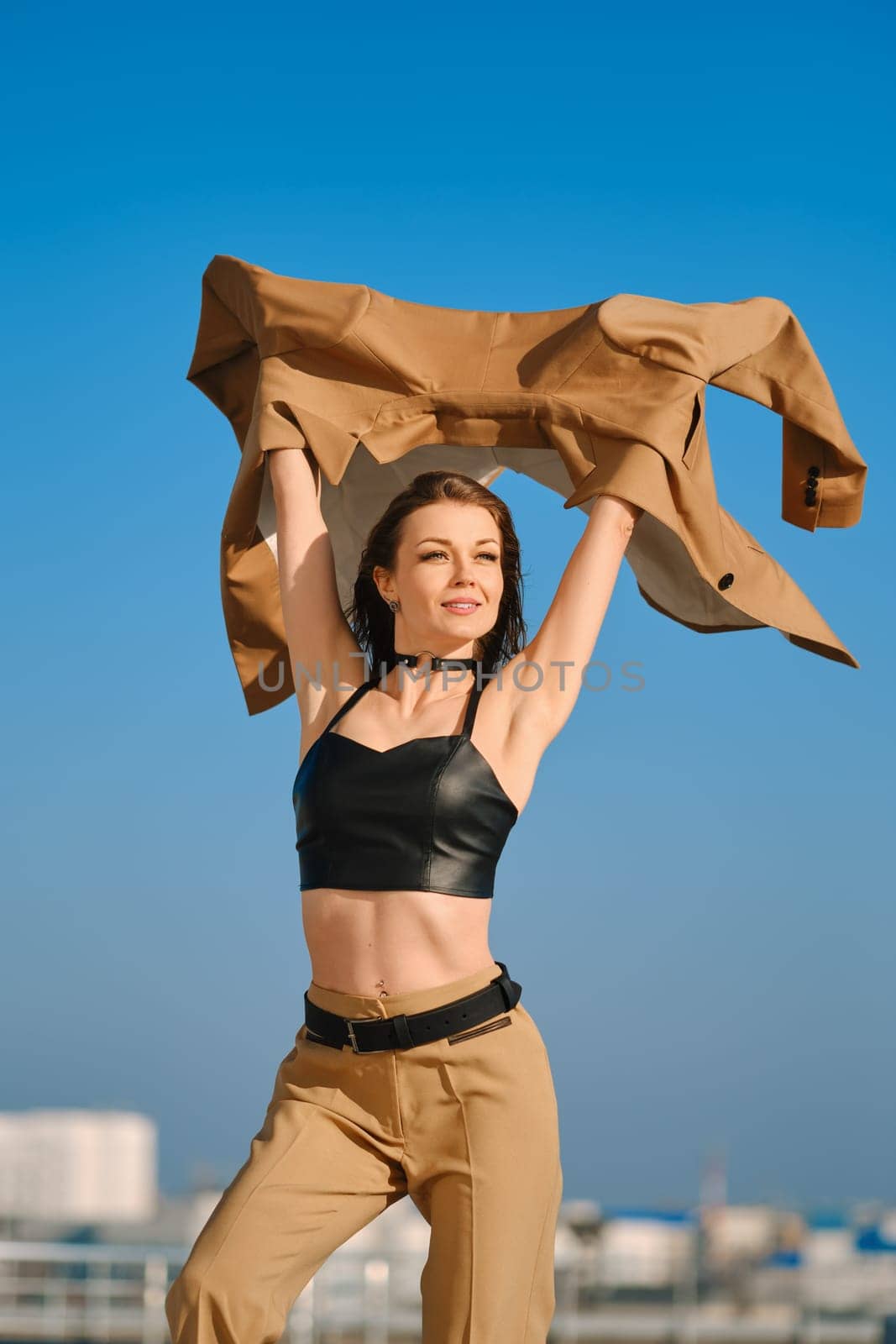Street fashion, women casual and trendy outfit. Woman in pantsuit, leather tank-top and rough boots outdoor.