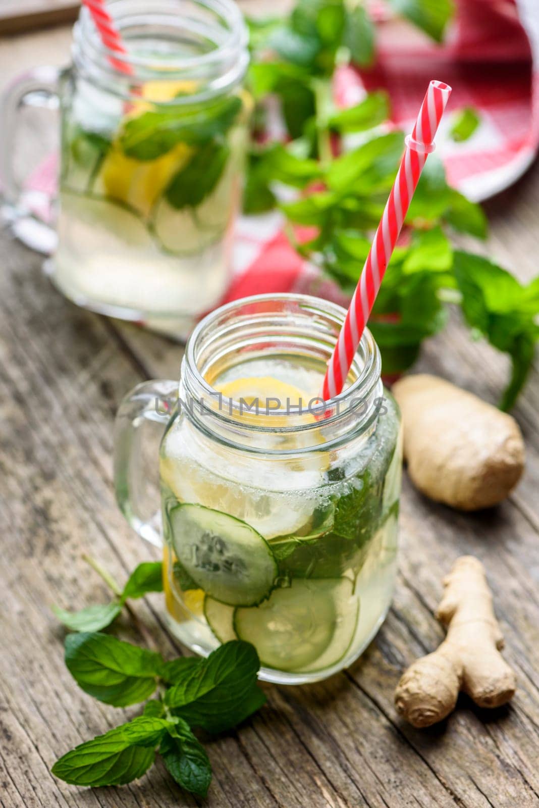 Healthy eating lifestyle concept. Homemade detox lemonade with cucumber, ginger and mint in retro mason jar glass on wooden table. Summer refreshment dring recipe.