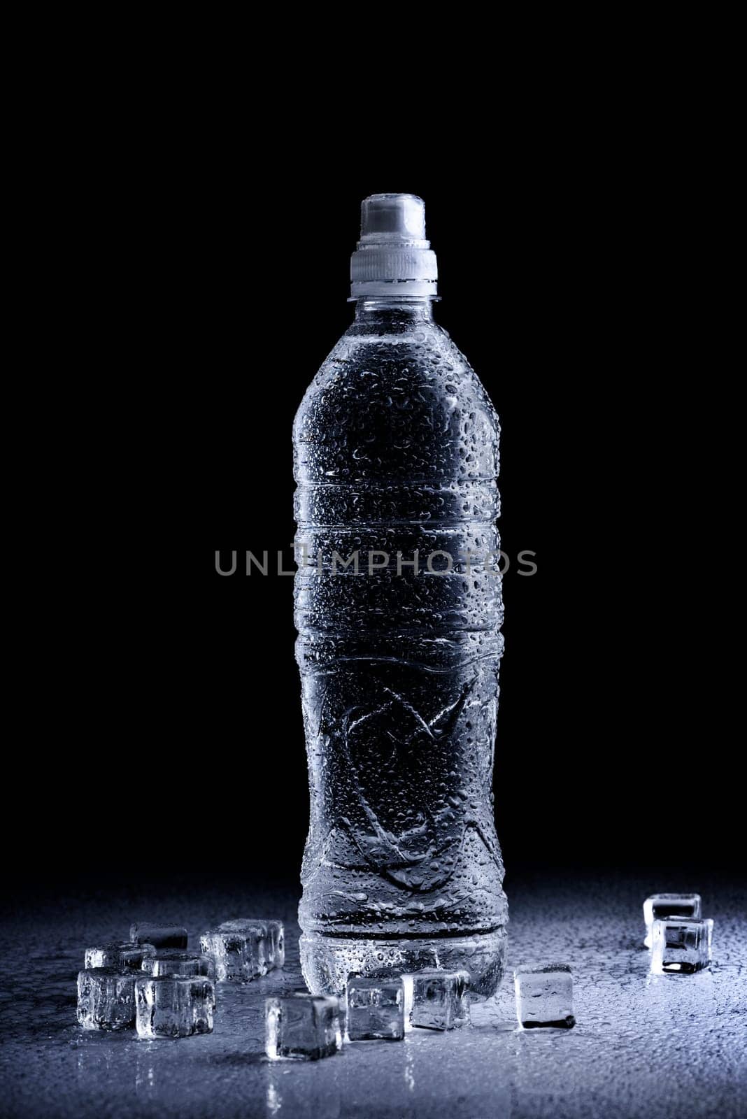 Fresh drinking mineral water in plastic bottle on black background. Healthy living concept.