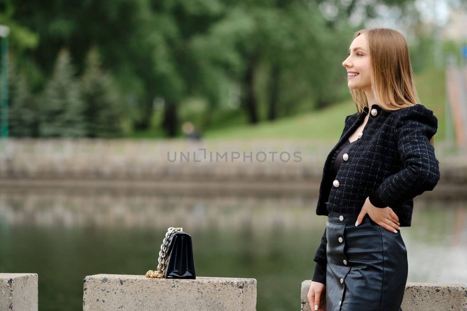 Young cheerful woman posing outdoor with a river on background